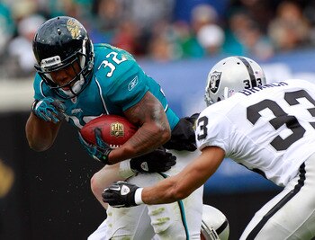 JACKSONVILLE, FL - DECEMBER 12:  Maurice Jones-Drew #32 of the Jacksonville Jaguars attempts to run past Tyvon Branch #33 of the Oakland Raiders during the game at EverBank Field on December 12, 2010 in Jacksonville, Florida.  (Photo by Sam Greenwood/Gett