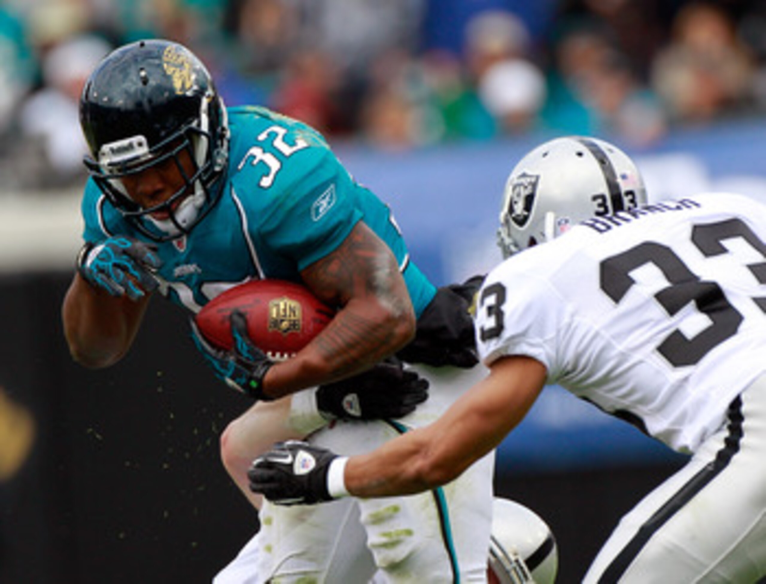 JACKSONVILLE, FL - DECEMBER 12:  Maurice Jones-Drew #32 of the Jacksonville Jaguars attempts to run past Tyvon Branch #33 of the Oakland Raiders during the game at EverBank Field on December 12, 2010 in Jacksonville, Florida.  (Photo by Sam Greenwood/Gett