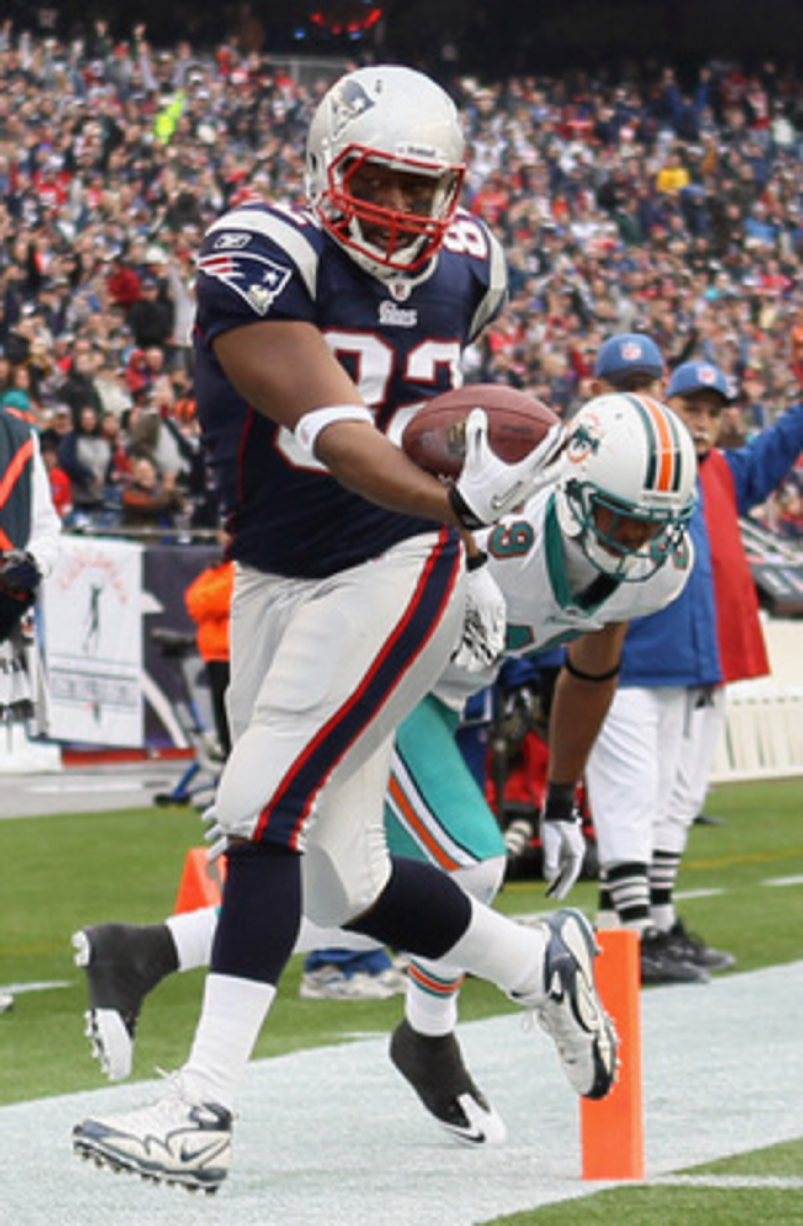 FOXBORO, MA - JANUARY 02:  Alge Crumpler #82 of the New England Patriots gets pushed out of bounds at the 2 yard line by Tyrone Culver #29 of the Miami Dolphins on January 2, 2011 at Gillette Stadium in Foxboro, Massachusetts.  (Photo by Elsa/Getty Images