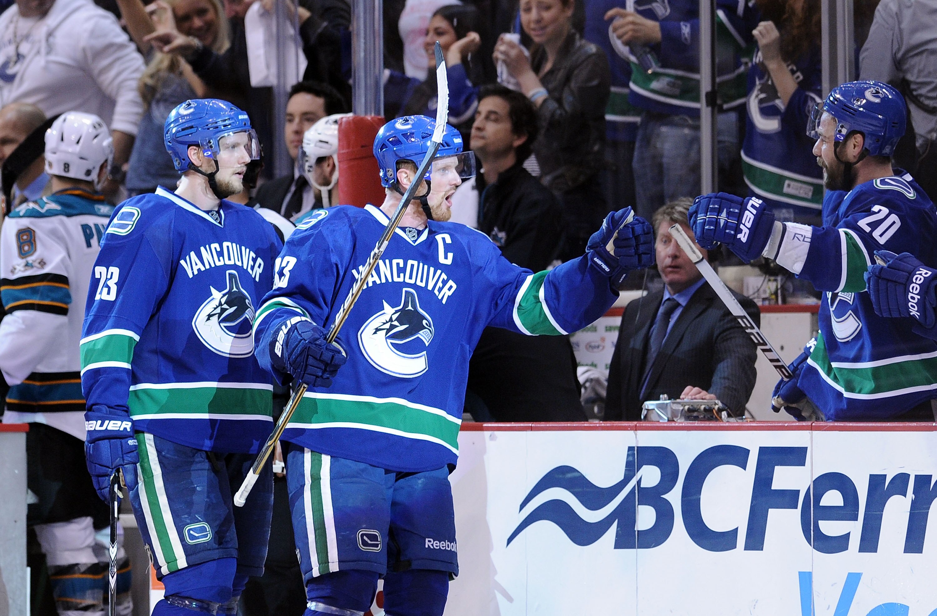 VANCOUVER, CANADA - MAY 24:  Alexander Edler #23 and Henrik Sedin #33 of the Vancouver Canucks skate by the Canucks bench to celebrate with teammates after Kesler's game-tying goal late in the third period to send the game into overtime in Game Five of th