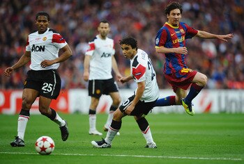 LONDON, ENGLAND - MAY 28:  Luis Antonio Valencia of Manchester United (L) and teammate Fabio da Silva  (C) look on as Lionel Messi of FC Barcelona (R) takes a shot during the UEFA Champions League final between FC Barcelona and Manchester United FC at Wem