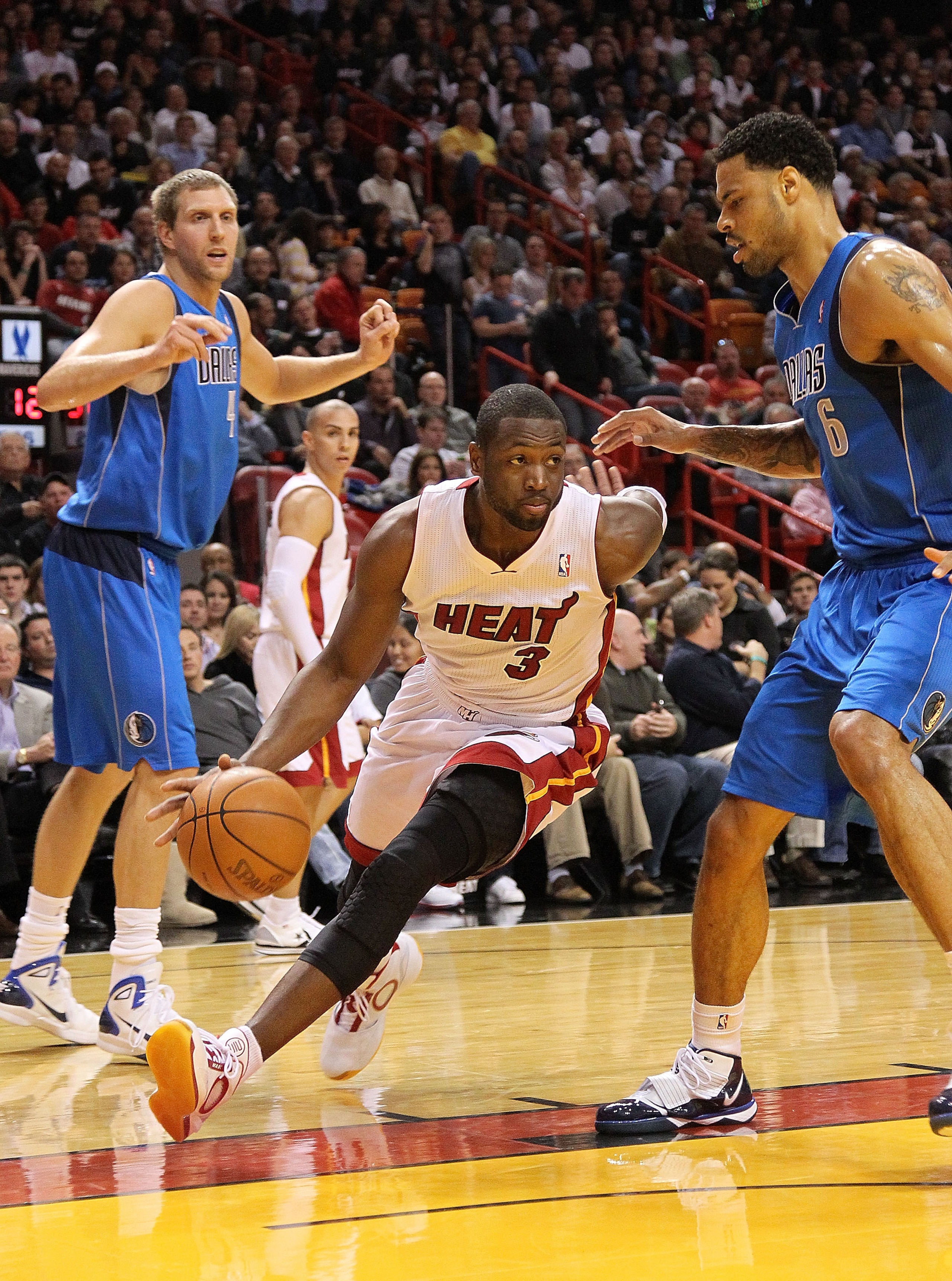 MIAMI, FL - DECEMBER 20:  Dwyane Wade #3 of the Miami Heat drives past Tyson Chandler #6 of the Dallas Mavericks during a game at American Airlines Arena on December 20, 2010 in Miami, Florida. NOTE TO USER: User expressly acknowledges and agrees that, by