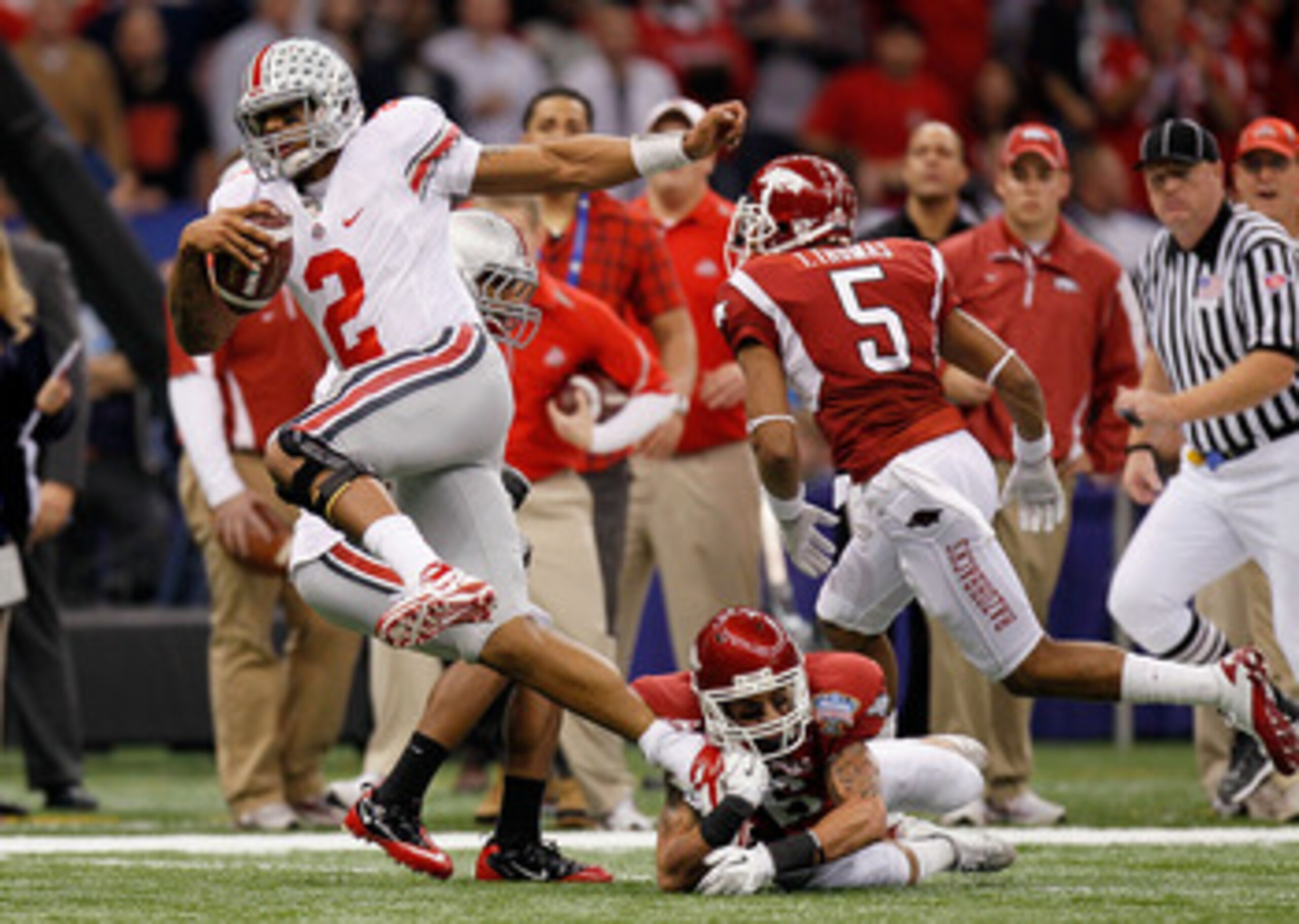NEW ORLEANS, LA - JANUARY 04:  Terrelle Pryor #2 of the Ohio State Buckeyes runs with the football as he avoids a tackle by Isaac Madison #6 of the Arkansas Razorbacks in the first quarter during the Allstate Sugar Bowl at the Louisiana Superdome on Janua