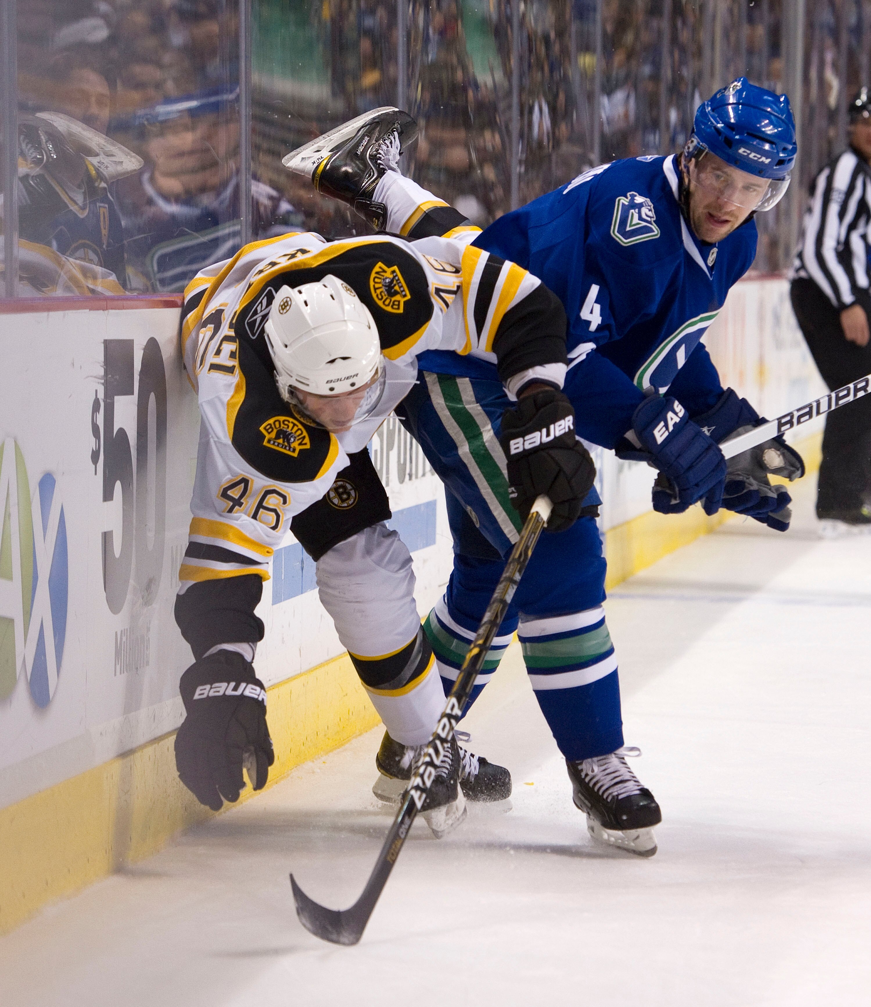VANCOUVER, CANADA - FEBRUARY 26: Keith Ballard #4 of the Vancouver Canucks delivers a hip check to David Krejci #46 of the Boston Bruins during the first period in NHL action on February 26, 2011 at Rogers Arena in Vancouver, British Columbia, Canada.  (P