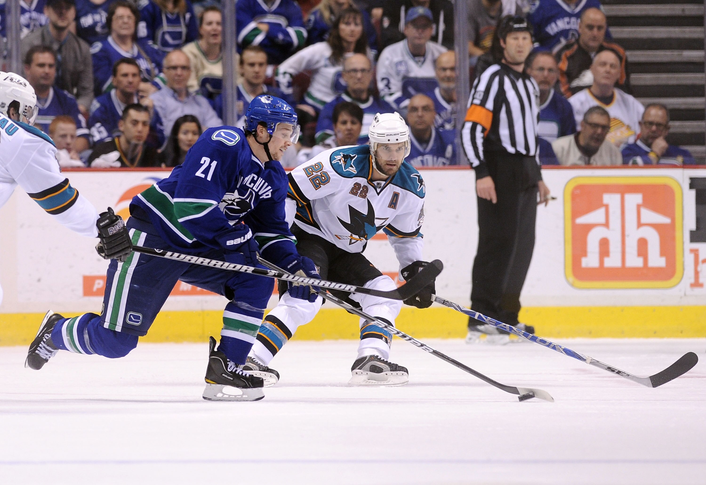 VANCOUVER, CANADA - MAY 15:  Mason Raymond #21 of the Vancouver Canucks controls the puck as Dan Boyle #22 of the San Jose Sharks defends the play in Game One of the Western Conference Finals during the 2011 Stanley Cup Playoffs at Rogers Arena on May 15,