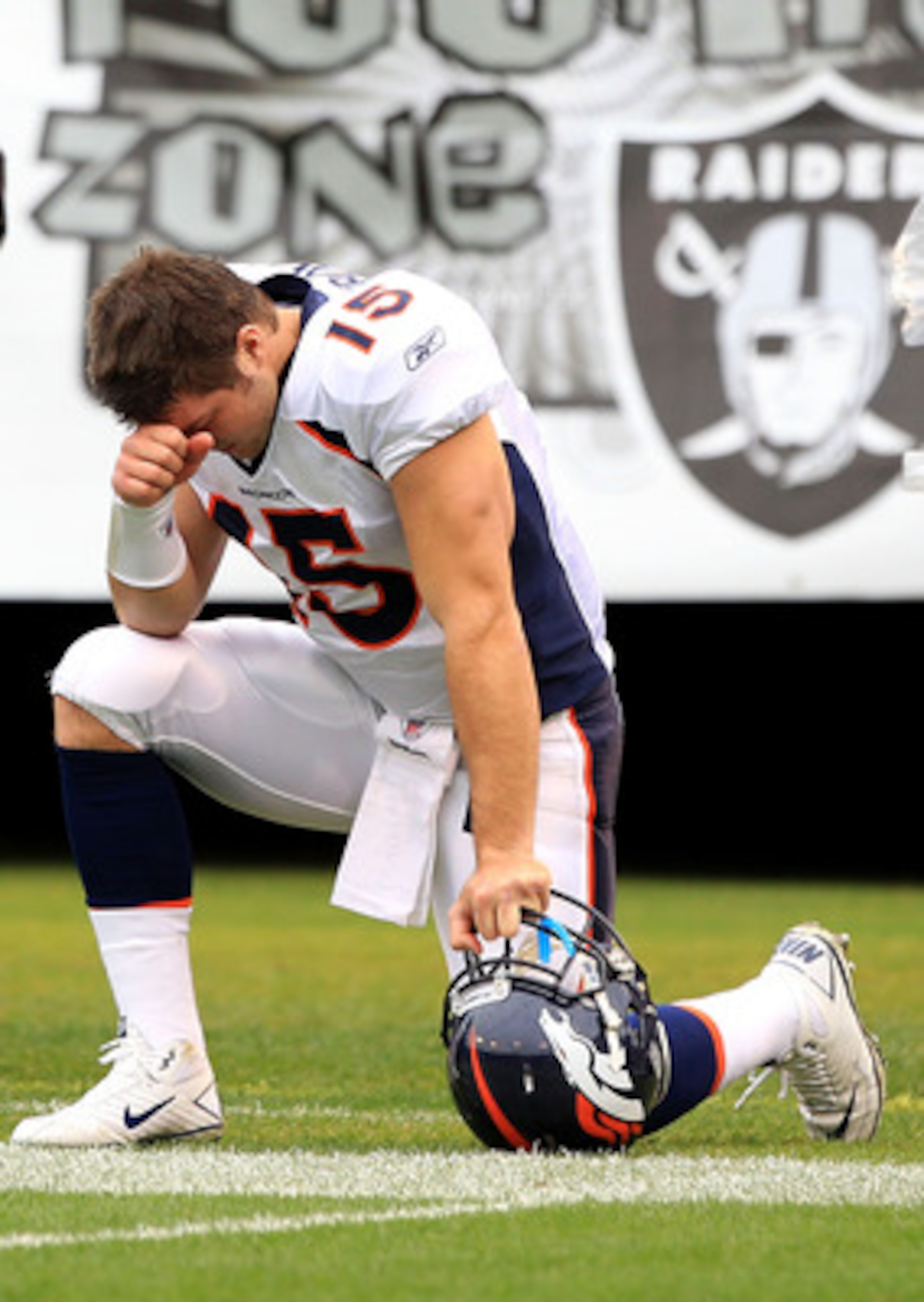 OAKLAND, CA - DECEMBER 19:  Tim Tebow #15 of the Denver Broncos kneels on the ground before their game against the Oakland Raiders at Oakland-Alameda County Coliseum on December 19, 2010 in Oakland, California.  (Photo by Ezra Shaw/Getty Images)