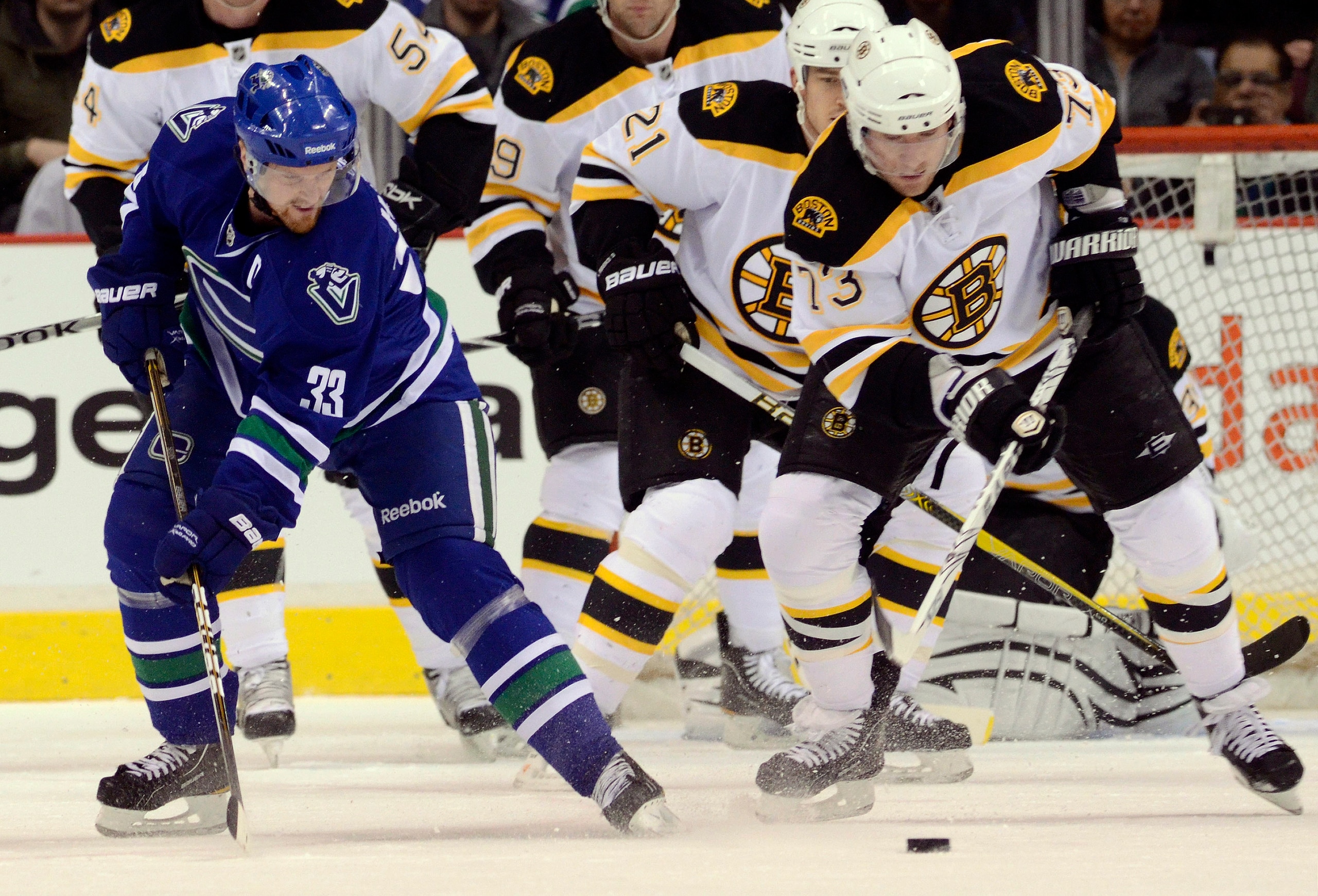 VANCOUVER, CANADA - FEBRUARY 26: Henrik Sedin #33 of the Vancouver Canucks is checked off the puck by Michael Ryder #73 of the Boston Bruins during the first period in NHL action on February 26, 2011 at Rogers Arena in Vancouver, British Columbia, Canada.