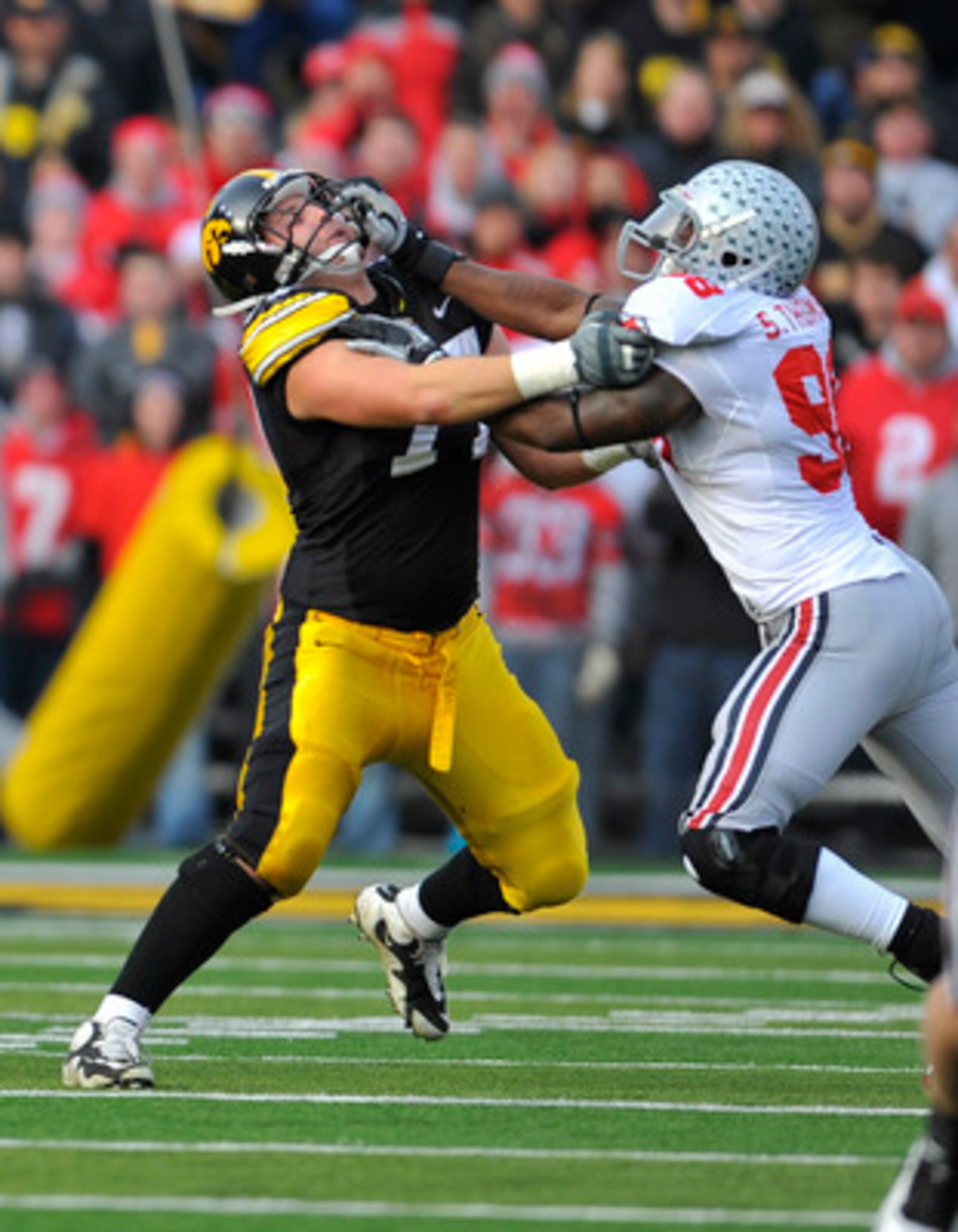 IOWA CITY, IA - NOVEMBER 20:  Quarterback Ricky Stanzi #12 of the University of Iowa Hawkeyes throws under pressure from defensive lineman Solomon Thomas #98 of the Ohio State Buckeyes as offensive lineman Riley Reiff #77 defends during the first half of