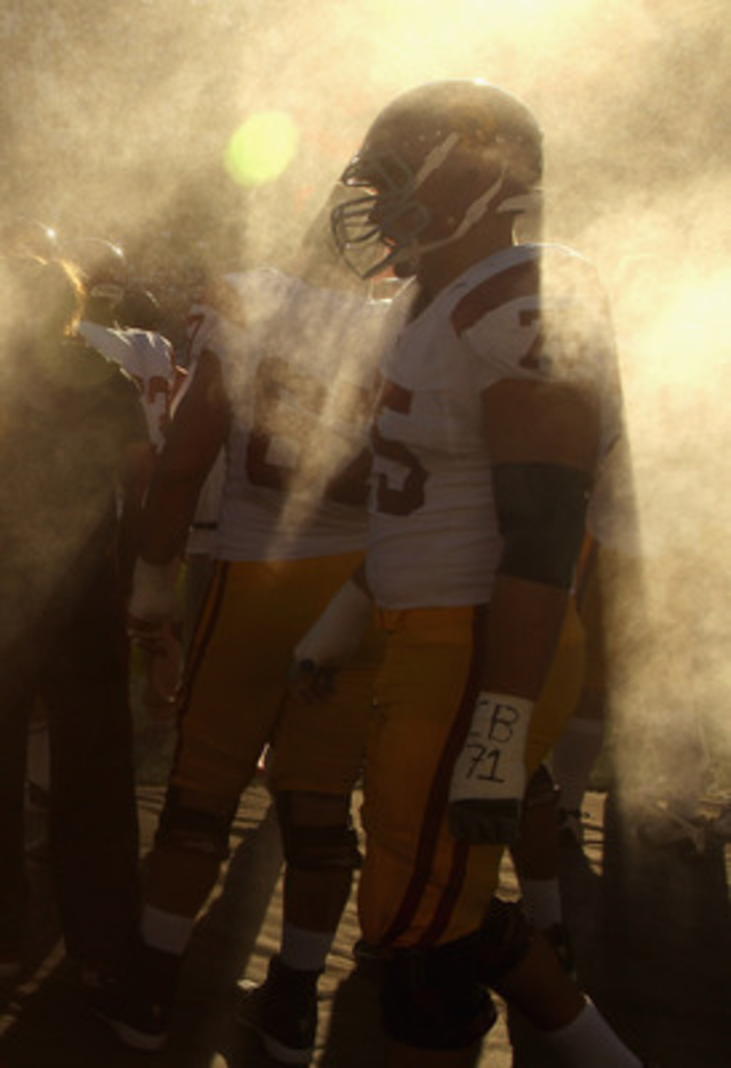 PALO ALTO, CA - OCTOBER 09:  Hebron Fangupo #92 and Matt Kalil #75 of the USC Trojans walk by a spray fan during their game against the Stanford Cardinal at Stanford Stadium on October 9, 2010 in Palo Alto, California.  (Photo by Ezra Shaw/Getty Images)