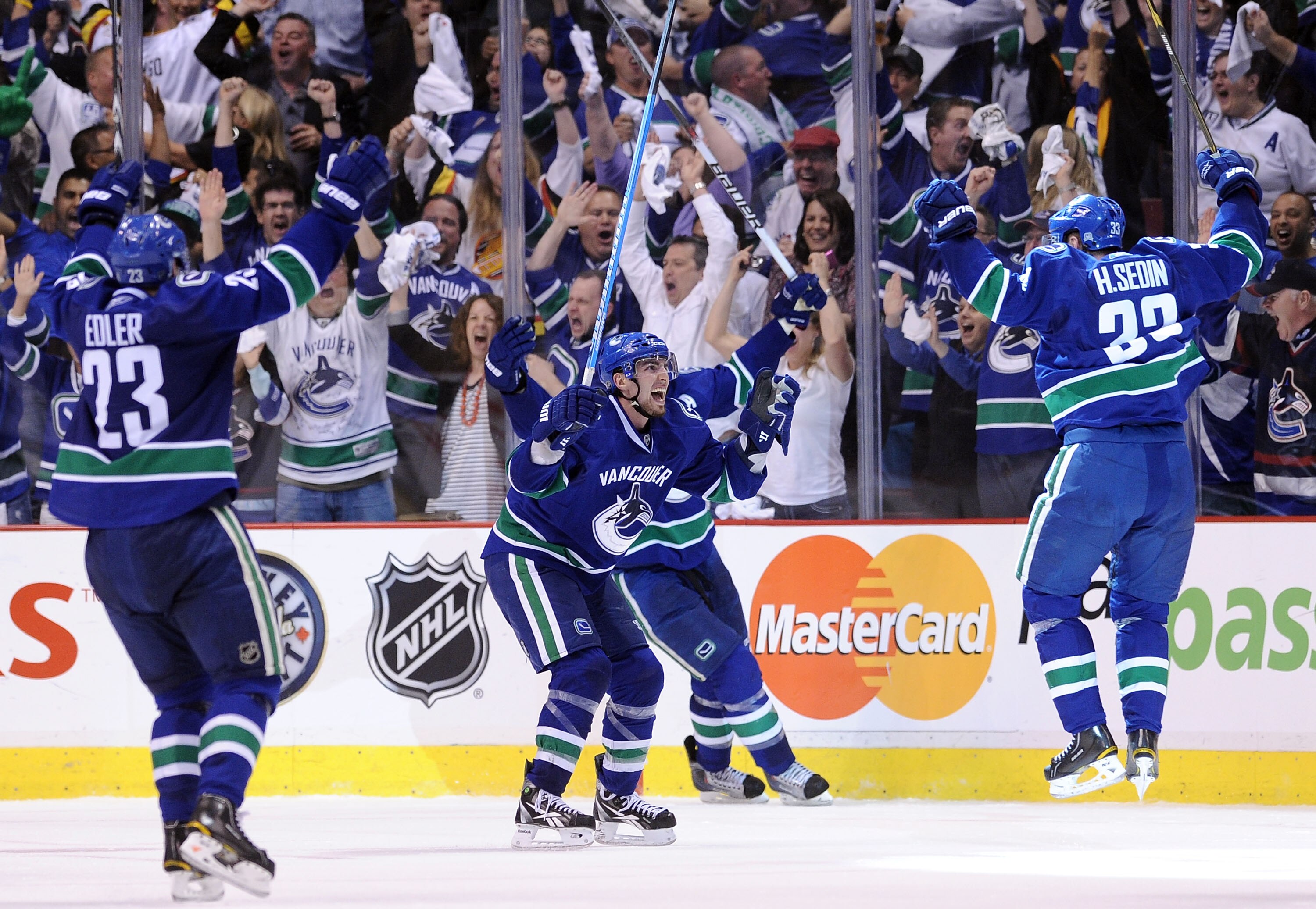 VANCOUVER, BC - MAY 24:  (L-R) Alexander Edler #23, Alex Burrows #14 and Henrik Sedin #33 of the Vancouver Canucks celebrate Kesler's game-tying goal at 2-2 with less than 14 seconds in the third period to send the game into overtime in Game Five of the W