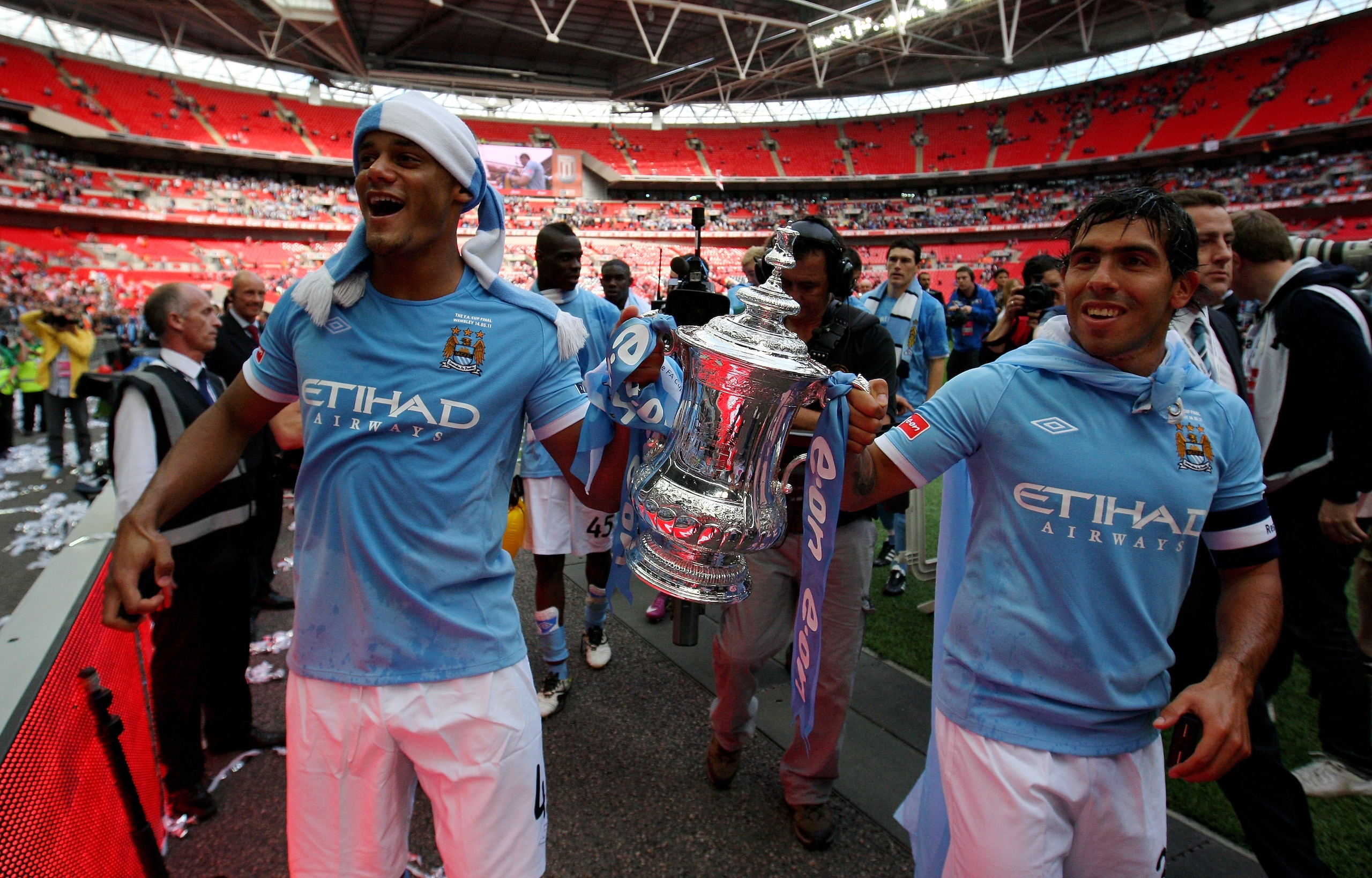 LONDON, ENGLAND - MAY 14:  Vincent Kompany (L) and Carlos Tevez of Manchester City hold the trophy after their team won the FA Cup sponsored by E.ON Final match between Manchester City and Stoke City at Wembley Stadium on May 14, 2011 in London, England.