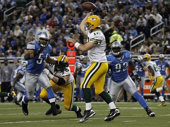 DETROIT - DECEMBER 12: Aaron Rogers #12 of the Green Bay Packers drops back to pass as DeAndre Levy #54 and Cliff Avrill #92 of the Detroit Lions rush the passer during the second quarter of the game against the Detroit Lions at Ford Field on December 12,