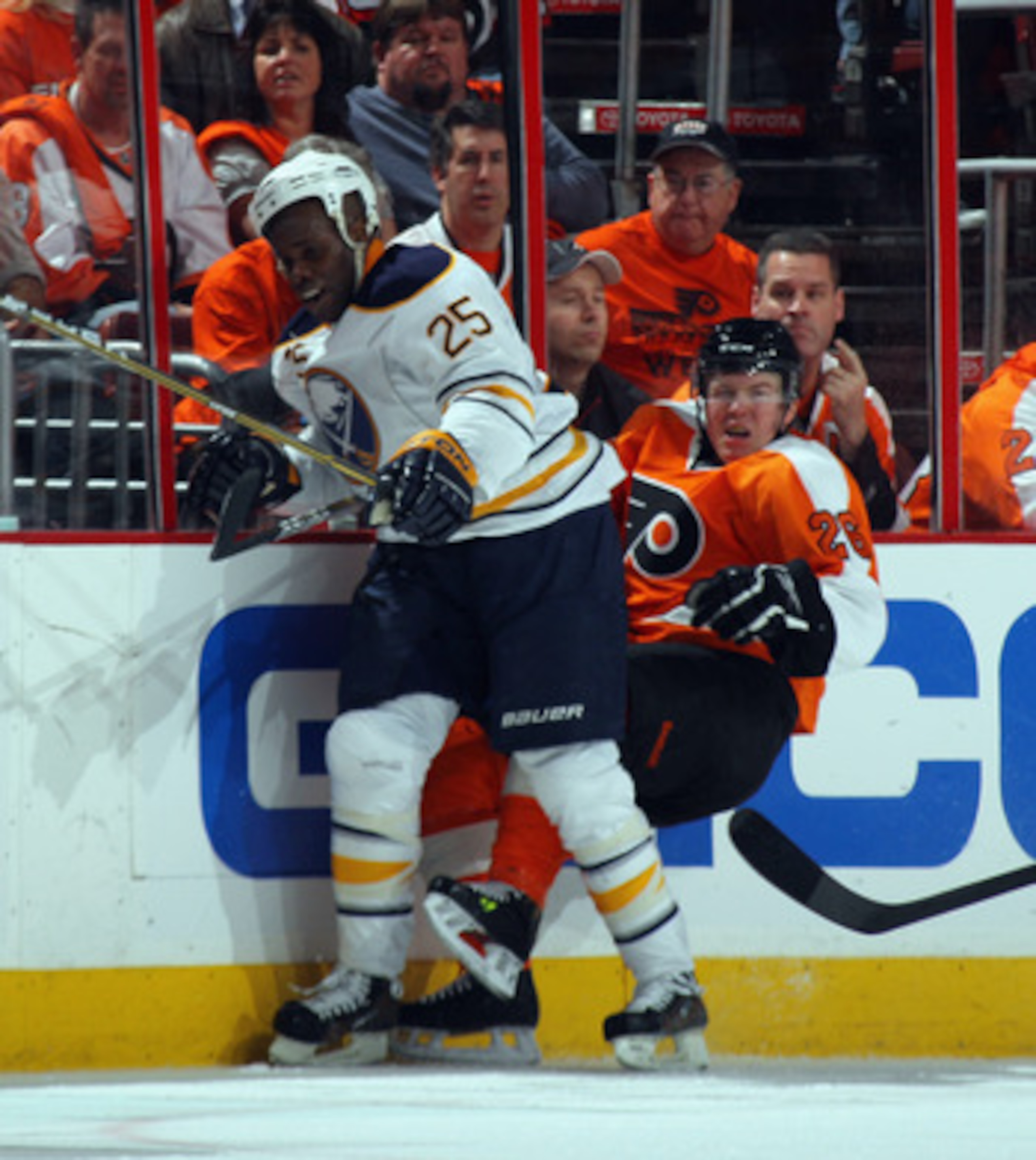 PHILADELPHIA, PA - APRIL 14: Mike Grier #25 of the Buffalo Sabres hits Danny Syvret #26 of the Philadelphia Flyers into the boards in Game One of the Eastern Conference Quarterfinals during the 2011 NHL Stanley Cup Playoffs at Wells Fargo Center on April