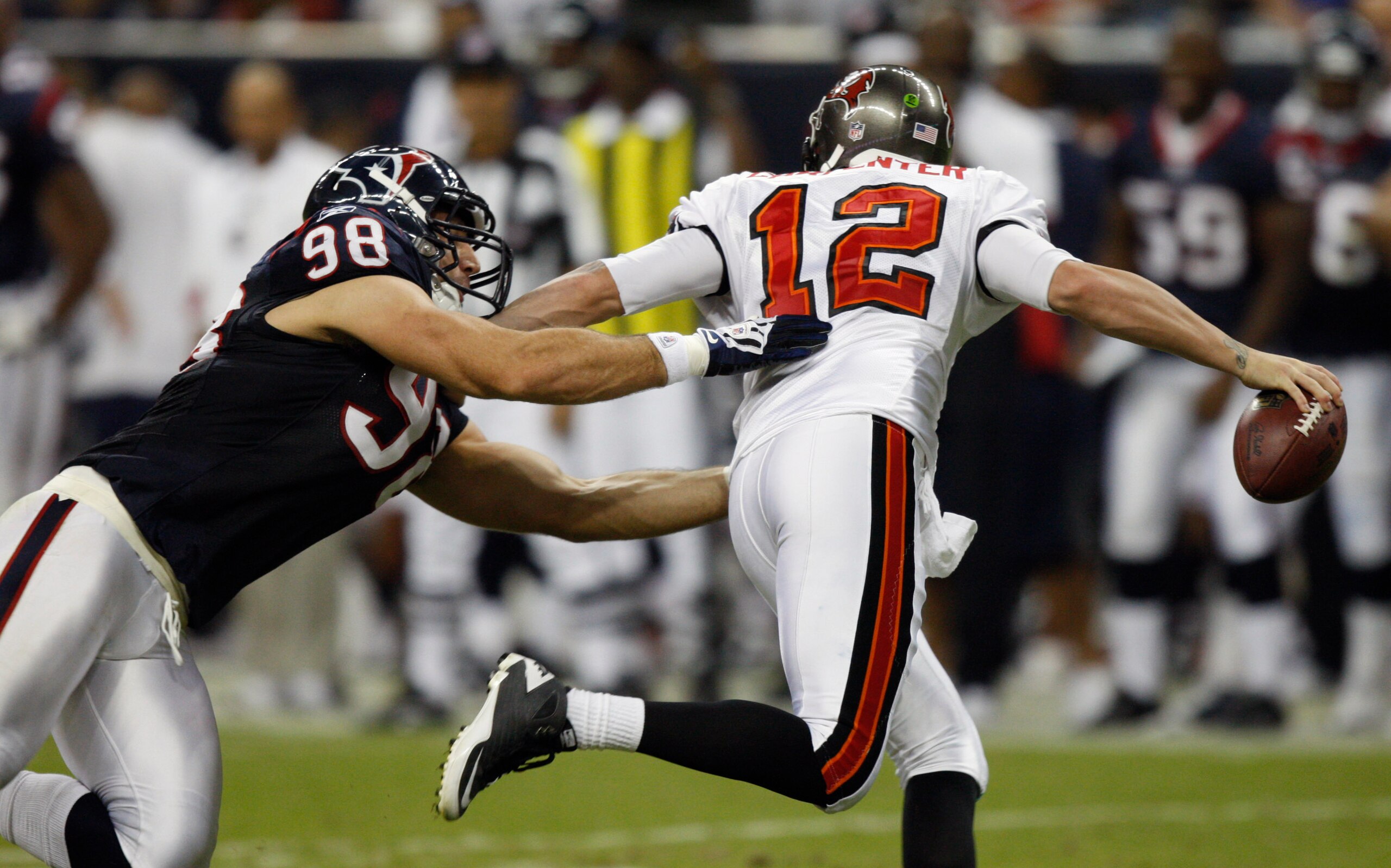 HOUSTON - SEPTEMBER 02:  Quarterback Rudy Carpenter #12 of the Tampa Bay Buccaneers scrambles out of the pocket as he is pressured by defensive end Connor Barwin #98 of the Houston Texans at Reliant Stadium on September 2, 2010 in Houston, Texas.  (Photo