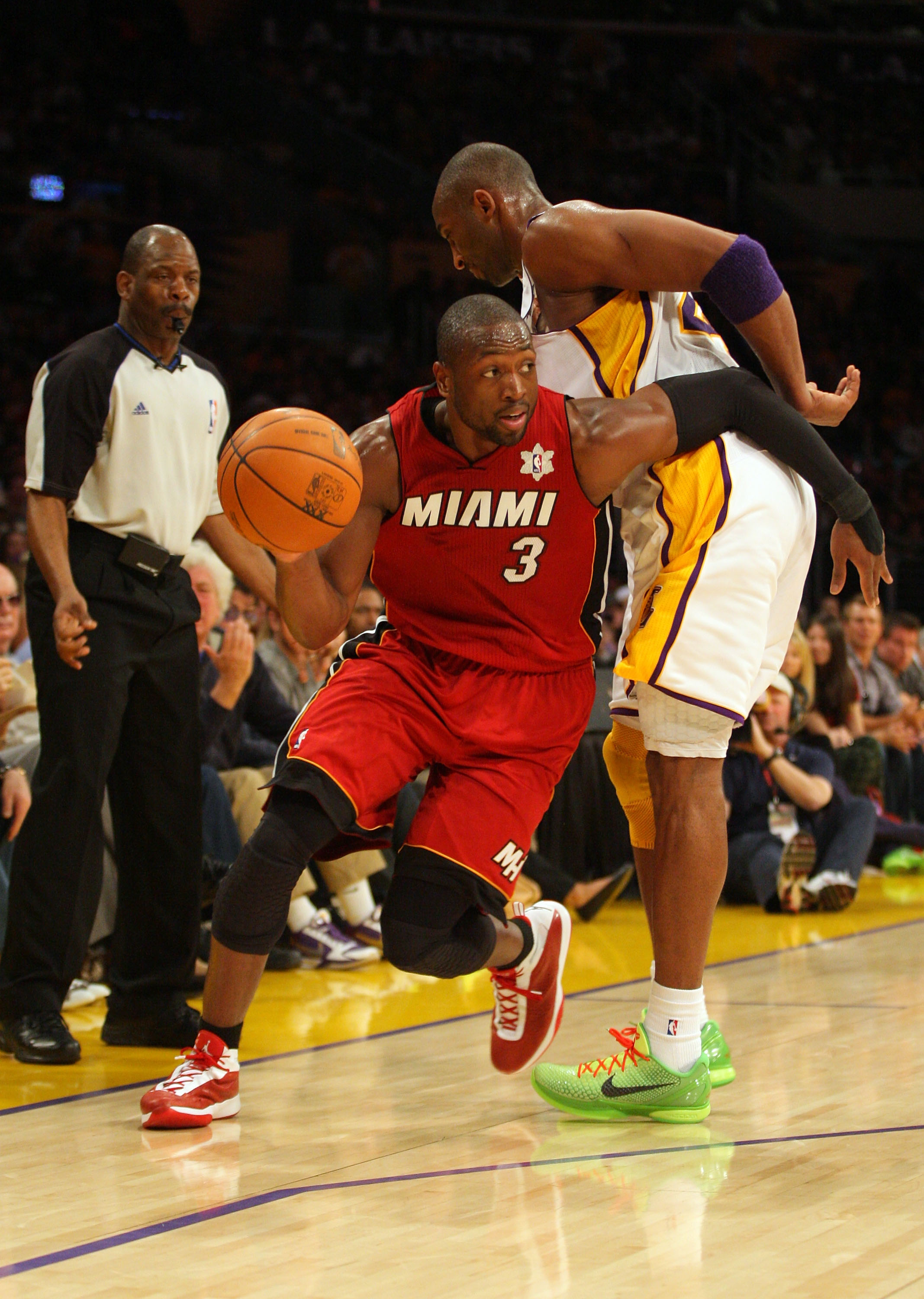 LOS ANGELES, CA - DECEMBER 25:  Dwyane Wade #3 of the Miami Heat dribbles the ball to the basket as Kobe Bryant #24 of the Los Angeles Lakers gets called for a blocking foul during the NBA game at Staples Center on December 25, 2010 in Los Angeles, Califo