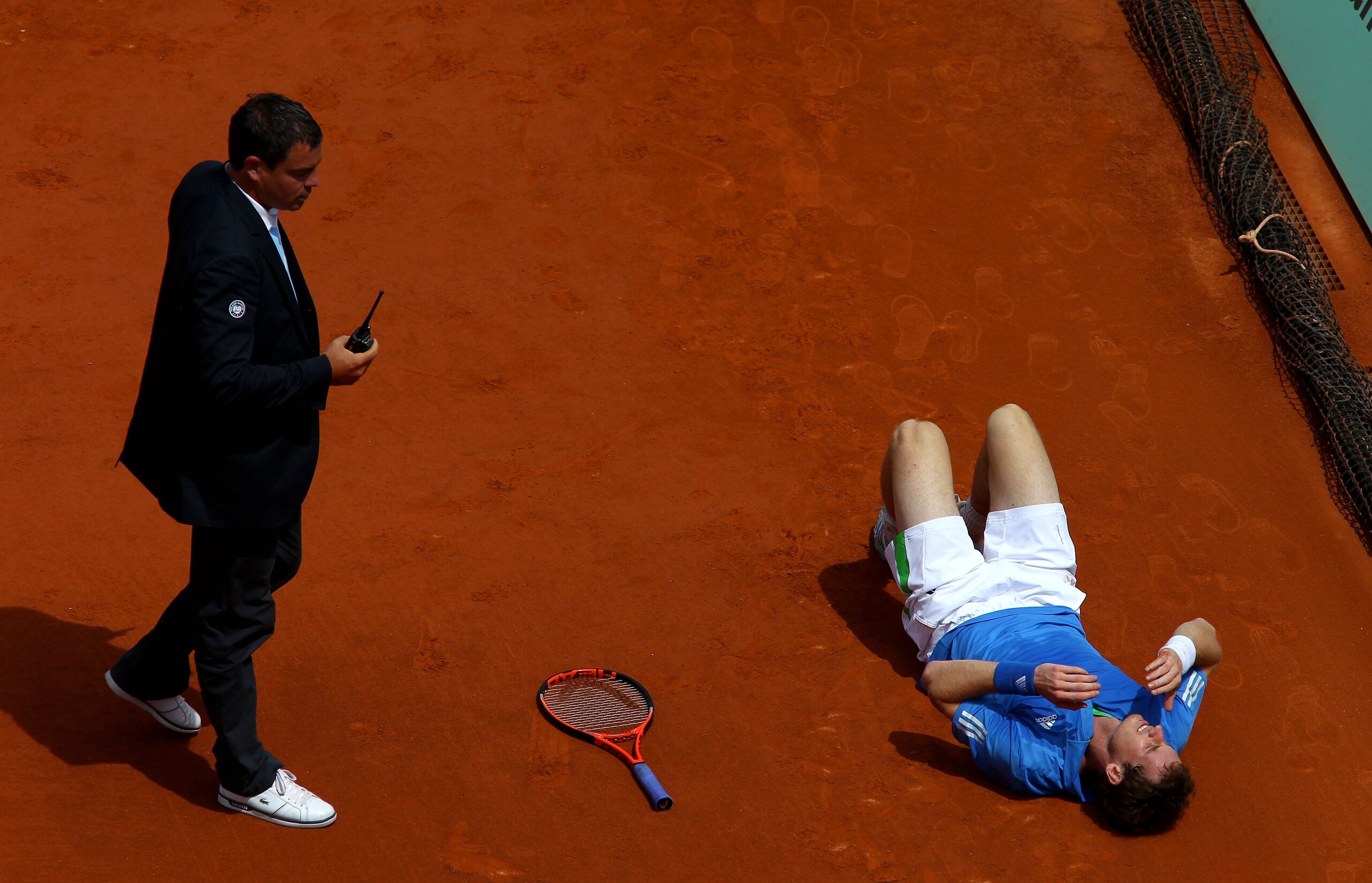 PARIS, FRANCE - MAY 28:  Andy Murray of Great Britain grimaces as lies on the court after injuring his foot during the men's singles round three match between Andy Murray of Great Britain and Michael Berrer of Germany on day seven of the French Open at Ro