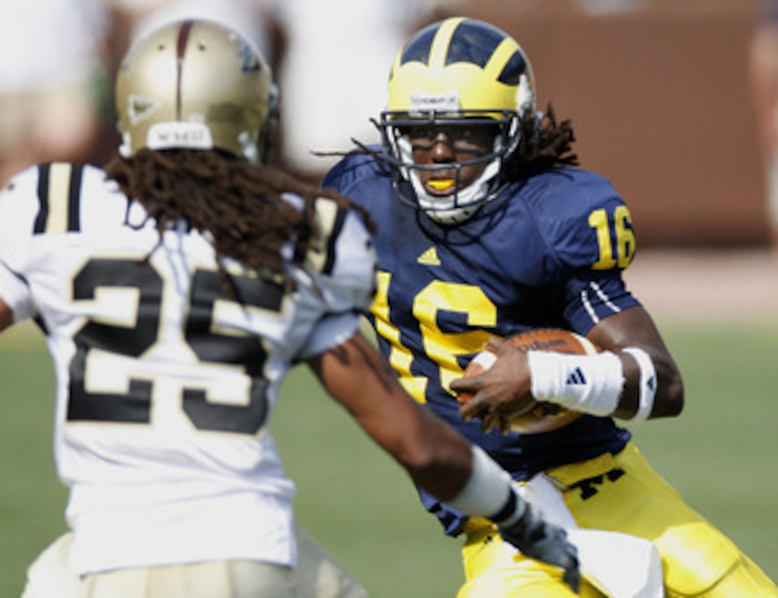 ANN ARBOR, MI - SEPTEMBER 05:  Denard Robinson #16 of the Michigan Wolverines gets around David Lewis #25 of the Western Michigan Broncos for a first quarter touchdown on September 5, 2009 at Michigan Stadium in Ann Arbor, Michigan.  (Photo by Gregory Sha