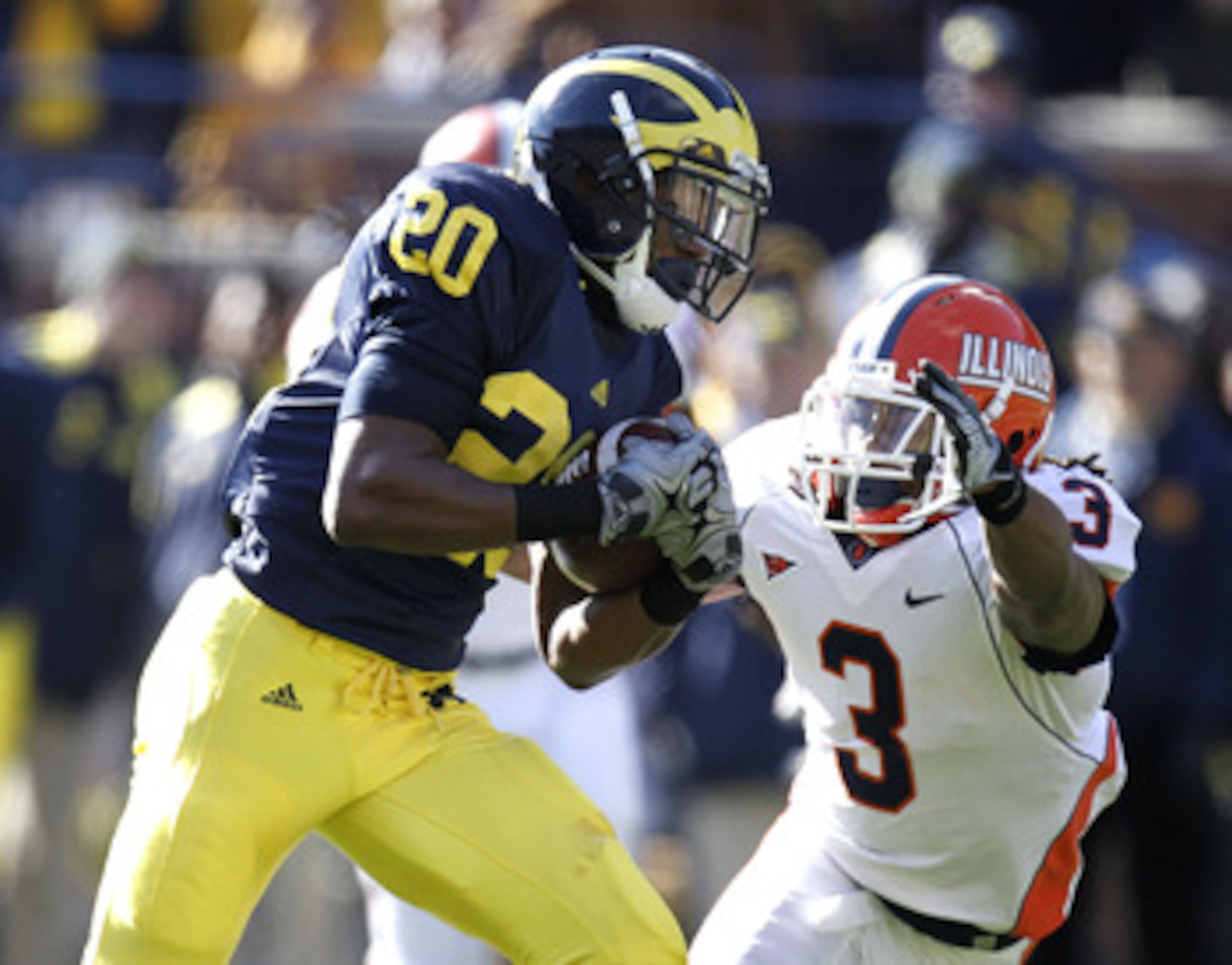 ANN ARBOR, MI - NOVEMBER 06:  Michael Shaw #20 of the Michigan Wolverines runs for a third quarter touchdown around the tackle of Tavon Wilson #3 of the Illinios Fighting Illini at Michigan Stadium on November 6, 2010 in Ann Arbor, Michigan. Michigan won