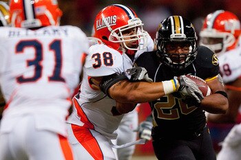 ST. LOUIS - SEPTEMBER 4: Ian Thomas #38 of the University of Illinois Fighting Illini wraps up De'Vion Moore #26 of the University of Missouri Tigers during the State Farm Arch Rivalry game on September 4, 2010 at the Edward Jones Dome in St. Louis, Misso