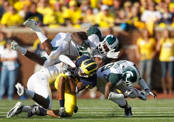 ANN ARBOR, MI - OCTOBER 09: Chris Norman #10 and Trenton Robinson #39 of the Michigan State Spartans make the stop on Dana Dixon #12 of the Michigan Wolverines during the game on October 9, 2010 at Michigan Stadium in Ann Arbor, Michigan. (Photo by Leon H