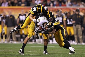 TEMPE, AZ - DECEMBER 28:  Wide receiver Michael Egnew #82 of the Missouri Tigers is tackled by James Morris #44 and Brett Greenwood #30 of the Iowa Hawkeyes after a 16 yard reception during the Insight Bowl at Sun Devil Stadium on December 28, 2010 in Tem
