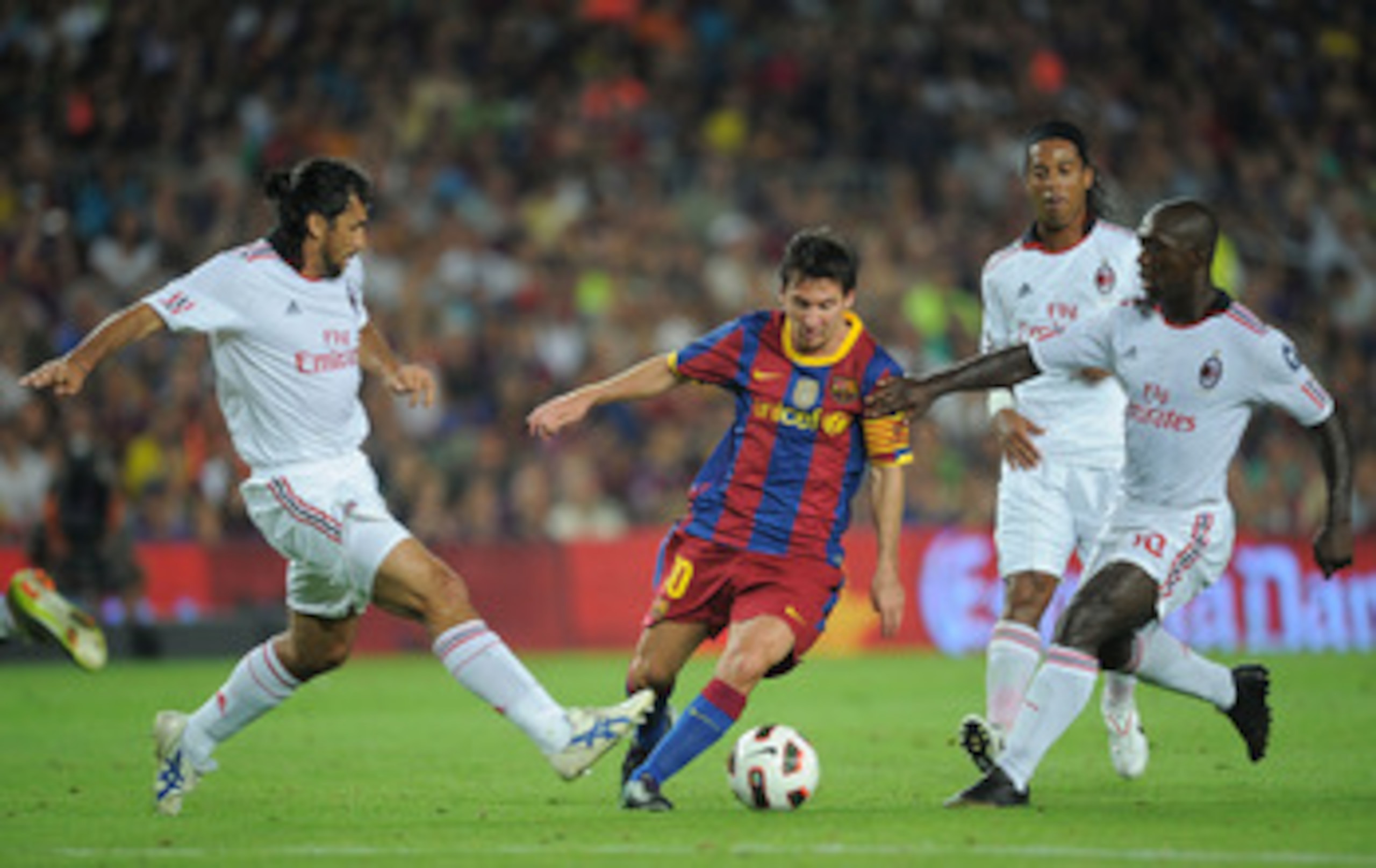 BARCELONA, SPAIN - AUGUST 25:  Leo Messi of Barcelona dribbles the ball between Manuel Alberto Yepes (L) and Clarence Seedorf of AC Milan during the Joan Gamper Trophy match between Barcelona and AC Milan at Camp Nou stadium on August 25, 2010 in Barcelon