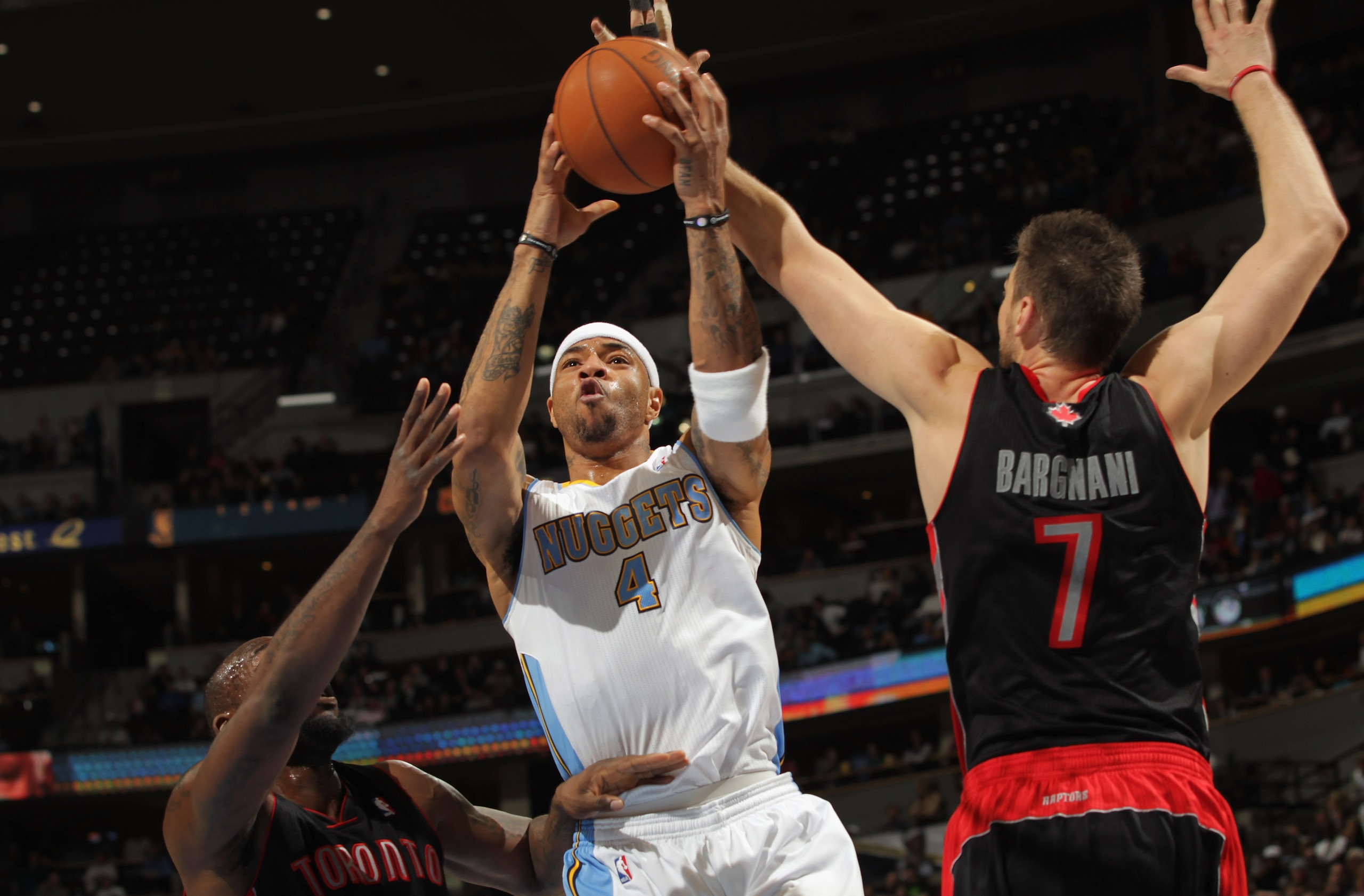 DENVER, CO - MARCH 21:  Kenyon Martin #4 of the Denver Nuggets lays up a shot between Reggie Evans #30 and Andrea Bargnani #7 of the Toronto Raptors at the Pepsi Center on March 21, 2011 in Denver, Colorado. The Nuggets defeated the Raptors 123-90. NOTE T