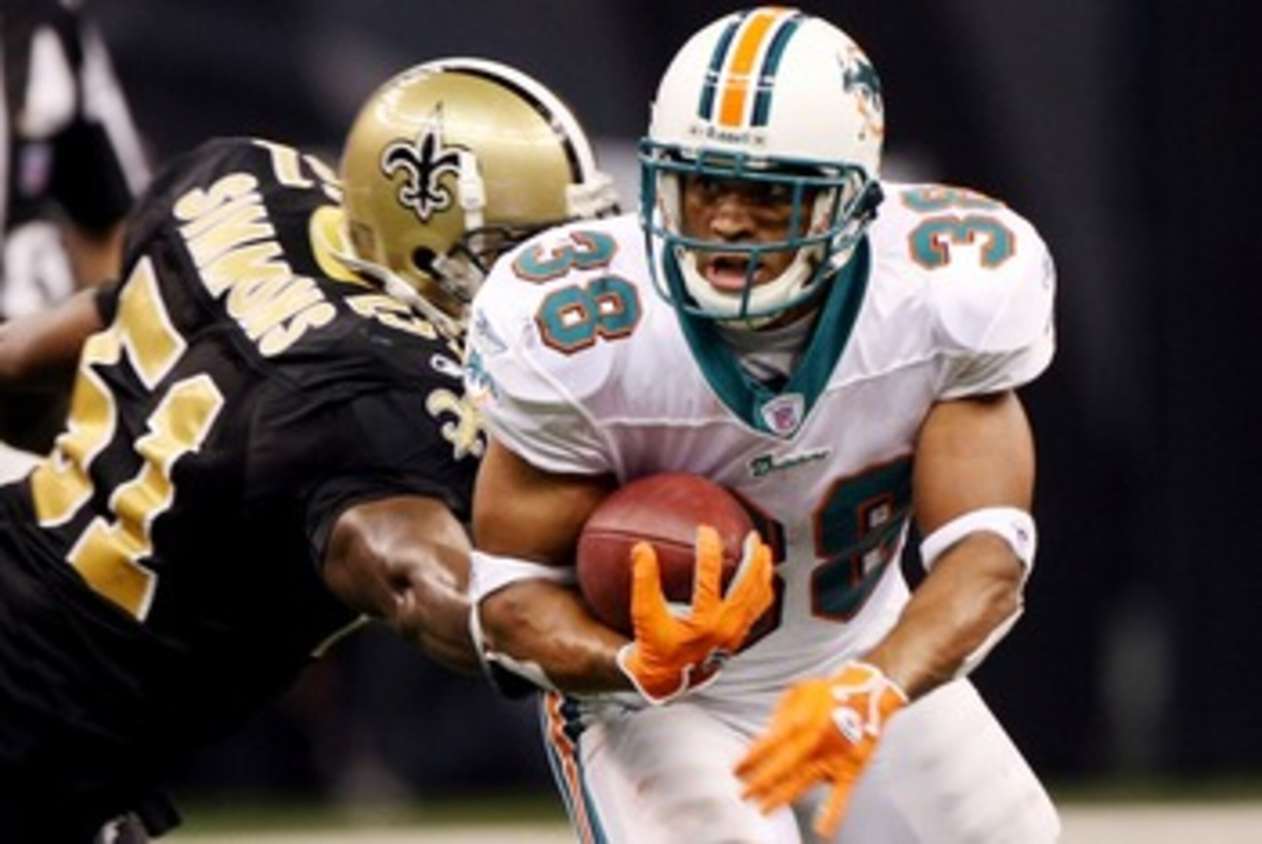 NEW ORLEANS - AUGUST 30:   Patrick Cobbs #38 of the Miami Dolphins avoids a tackle by Brian Simmons #51 of the New Orleans Saints on August 30, 2007 at the Superdome in New Orleans, Louisiana.  (Photo by Chris Graythen/Getty Images)
