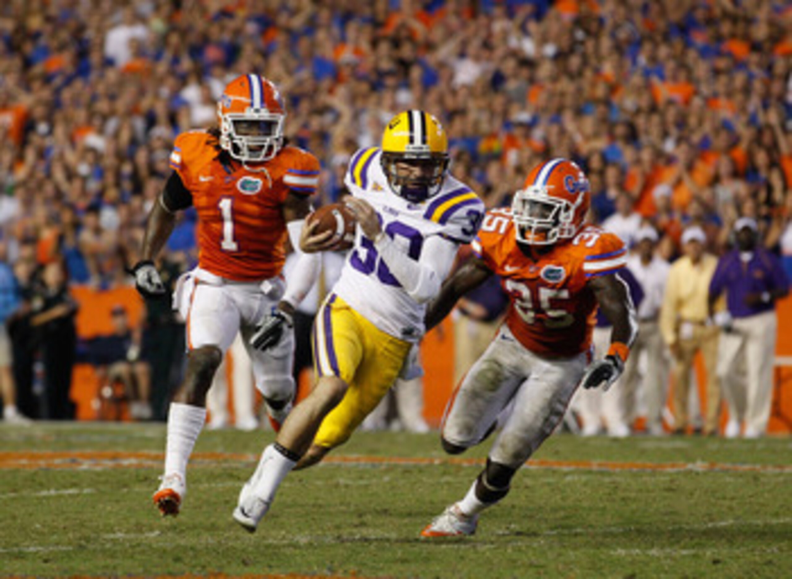 GAINESVILLE, FL - OCTOBER 09: Punter Josh Jasper #30 of the Louisiana State University Tigers runs a fake punt for yardage past Ahmad Black #35 and Janoris Jenkins #1 of the Florida Gators during the game at Ben Hill Griffin Stadium on October 9, 2010 in GAINESVILLE, FL - OCTOBER 09: Punter Josh Jasper #30 of the Louisiana State University Tigers runs a fake punt for yardage past Ahmad Black #35 and Janoris Jenkins #1 of the Florida Gators during the game at Ben Hill Griffin Stadium on October 9, 2010 in