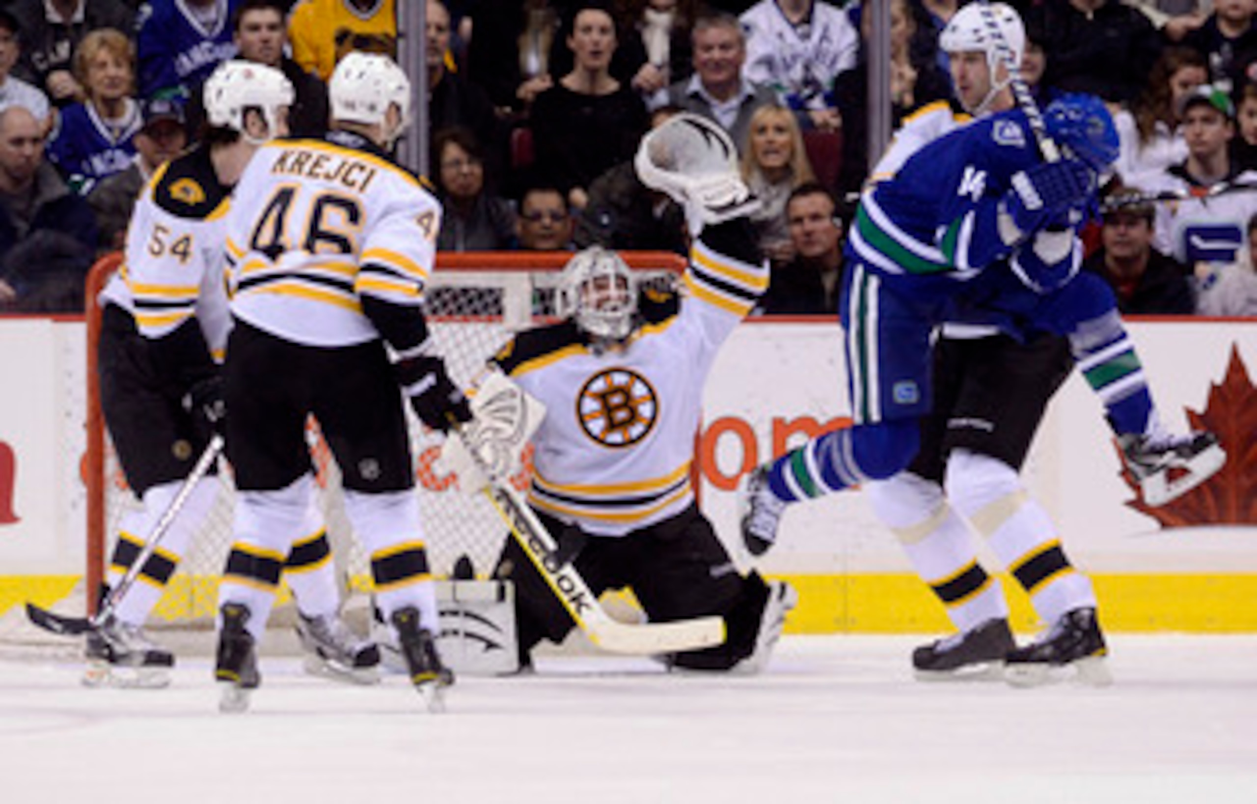 VANCOUVER, CANADA - FEBRUARY 26: Alexandre Burrows #14 of the Vancouver Canucks jumps out of the way of a shot as the puck sails over the head of goalie Tim Thomas #30 of the Boston Bruins during the third period in NHL action on February 26, 2011 at Roge
