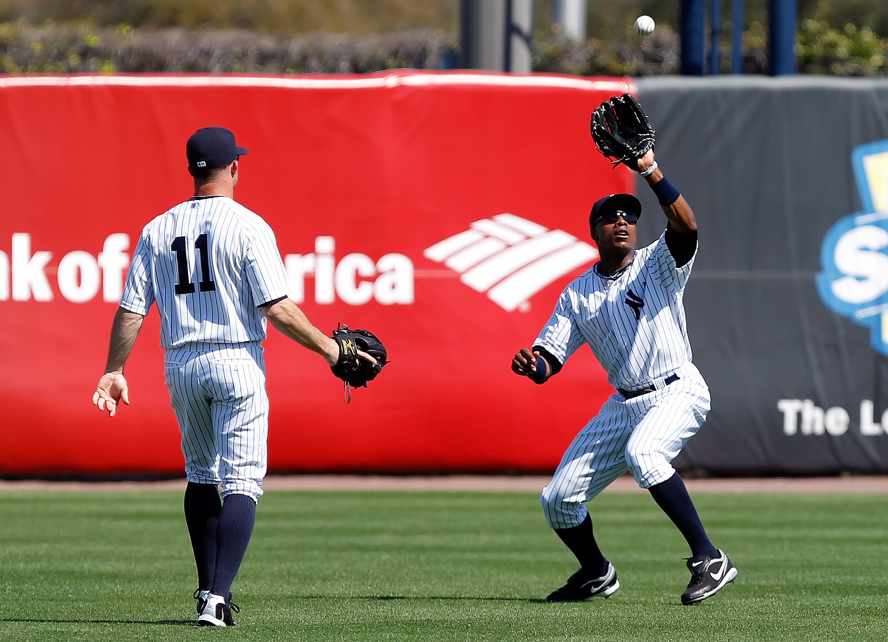TAMPA, FL - FEBRUARY 26:  Outfielder Curtis Granderson #14 of the New York Yankees catches a fly ball as outfielder Brett Gardner looks on against the Philadelphia Phillies during a Grapefruit League Spring Training Game at George M. Steinbrenner Field on
