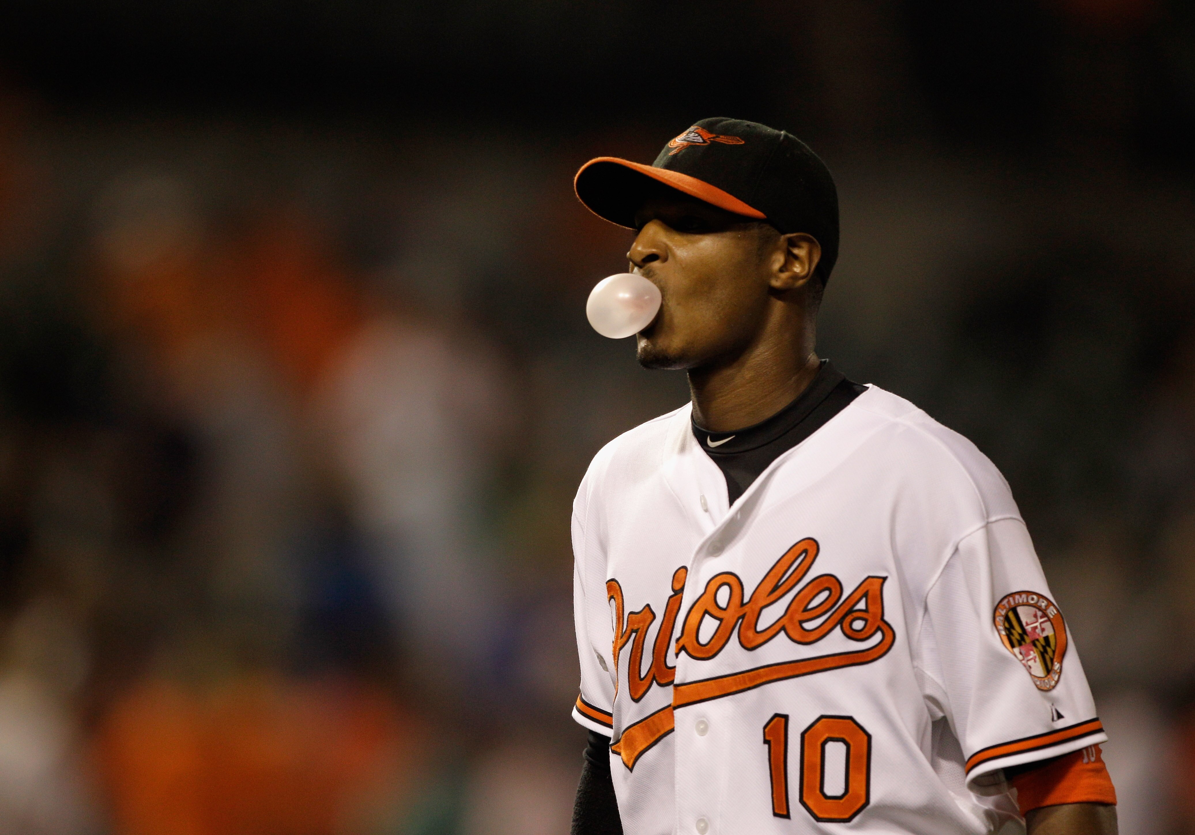 BALTIMORE, MD - MAY 25: Adam Jones #10 of the Baltimore Orioles blows a bubble while walking off the field after the Orioles defeated the Kansas City Royals 9-2 at Oriole Park at Camden Yards on May 25, 2011 in Baltimore, Maryland.  (Photo by Rob Carr/Get