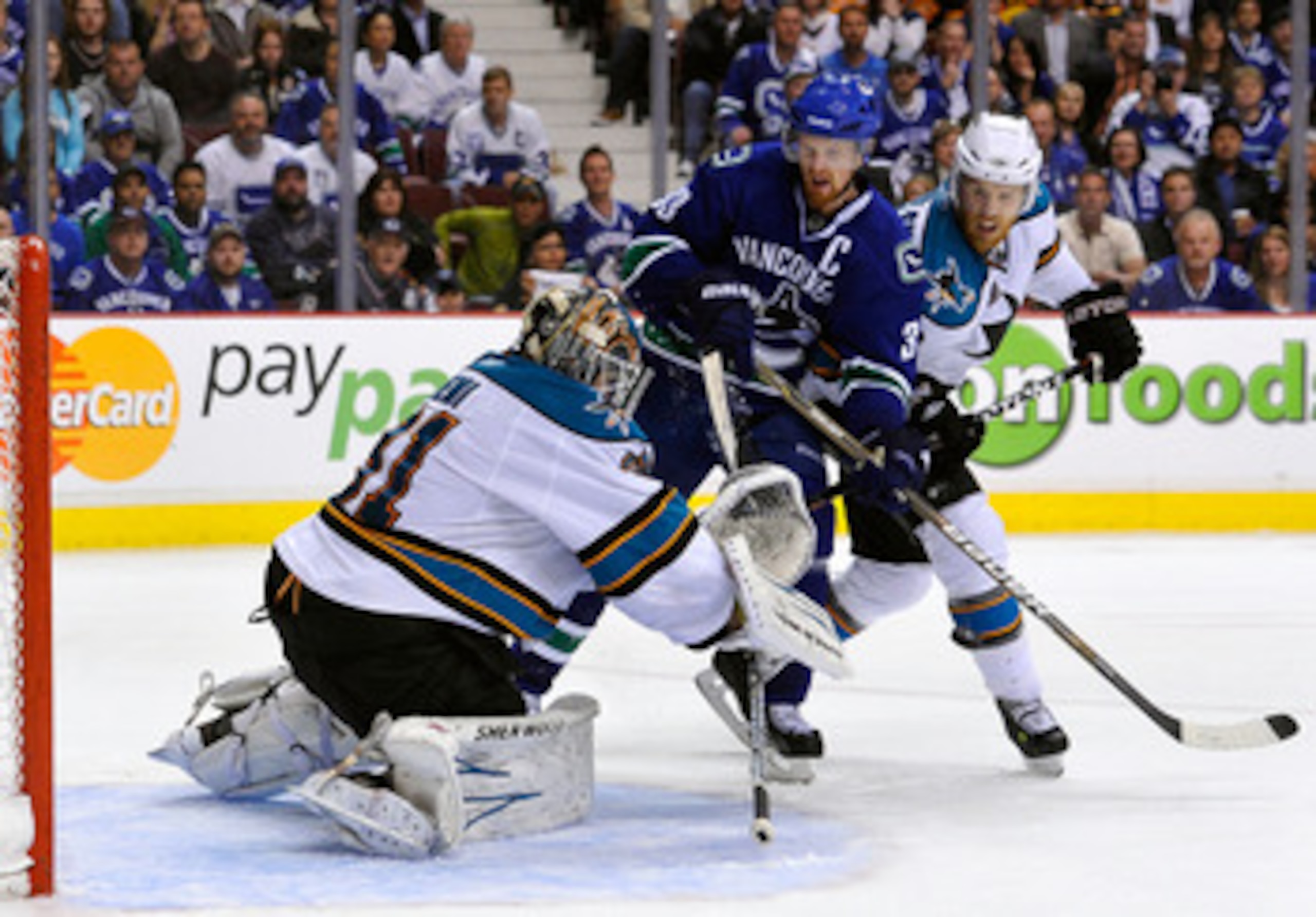 VANCOUVER, CANADA - MAY 24:  Joe Pavelski #8 of the San Jose Sharks defends Henrik Sedin #33 of the Vancouver Canucks as goaltender Antti Niemi #31 of the San Jose Sharks makes a save in Game Five of the Western Conference Finals during the 2011 Stanley C