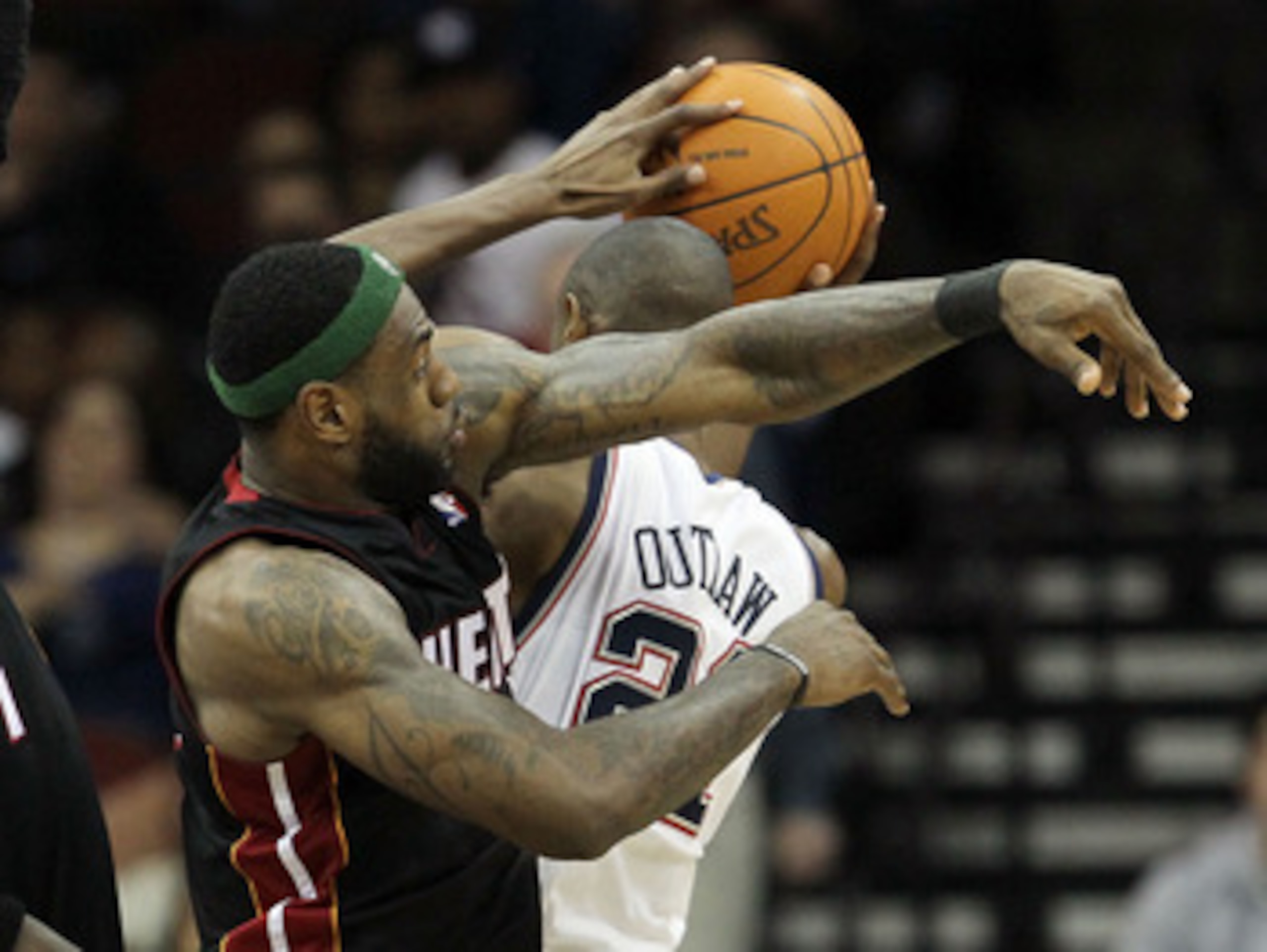 NEWARK, NJ - APRIL 03:  LeBron James #6 of the Miami Heat commits a foul against Travis Outlaw #21 of the New Jersey Nets at the Prudential Center on April 3, 2011 in Newark, New Jersey.The Heat defeated the Nets 108-94.NOTE TO USER: User expressly acknow