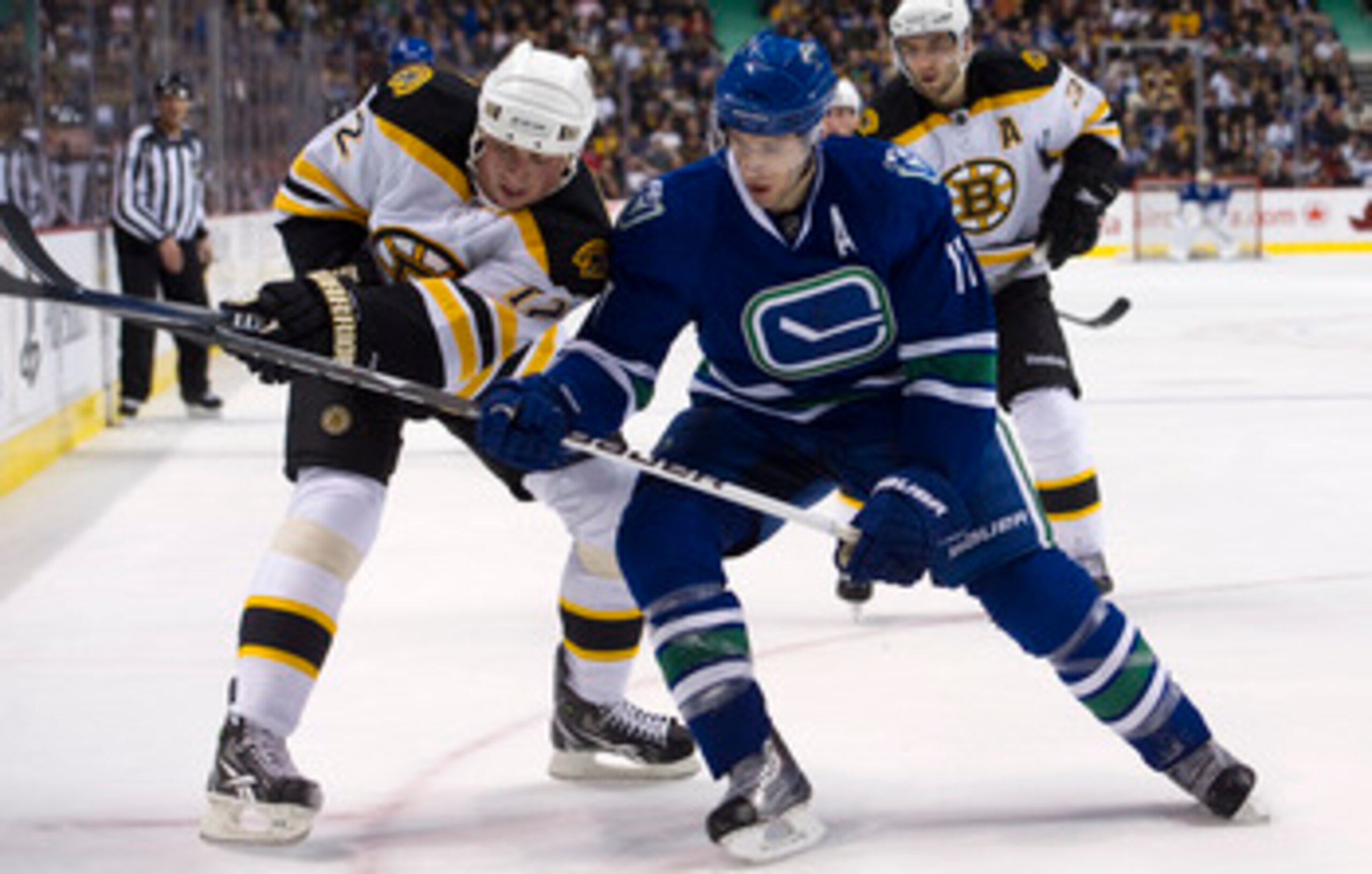 VANCOUVER, CANADA - FEBRUARY 26: Ryan Kesler #17 of the Vancouver Canucks battles with Tomas Kaberle #12 of the Boston Bruins while in the corner during the second period in NHL action on February 26, 2011 at Rogers Arena in Vancouver, British Columbia, C
