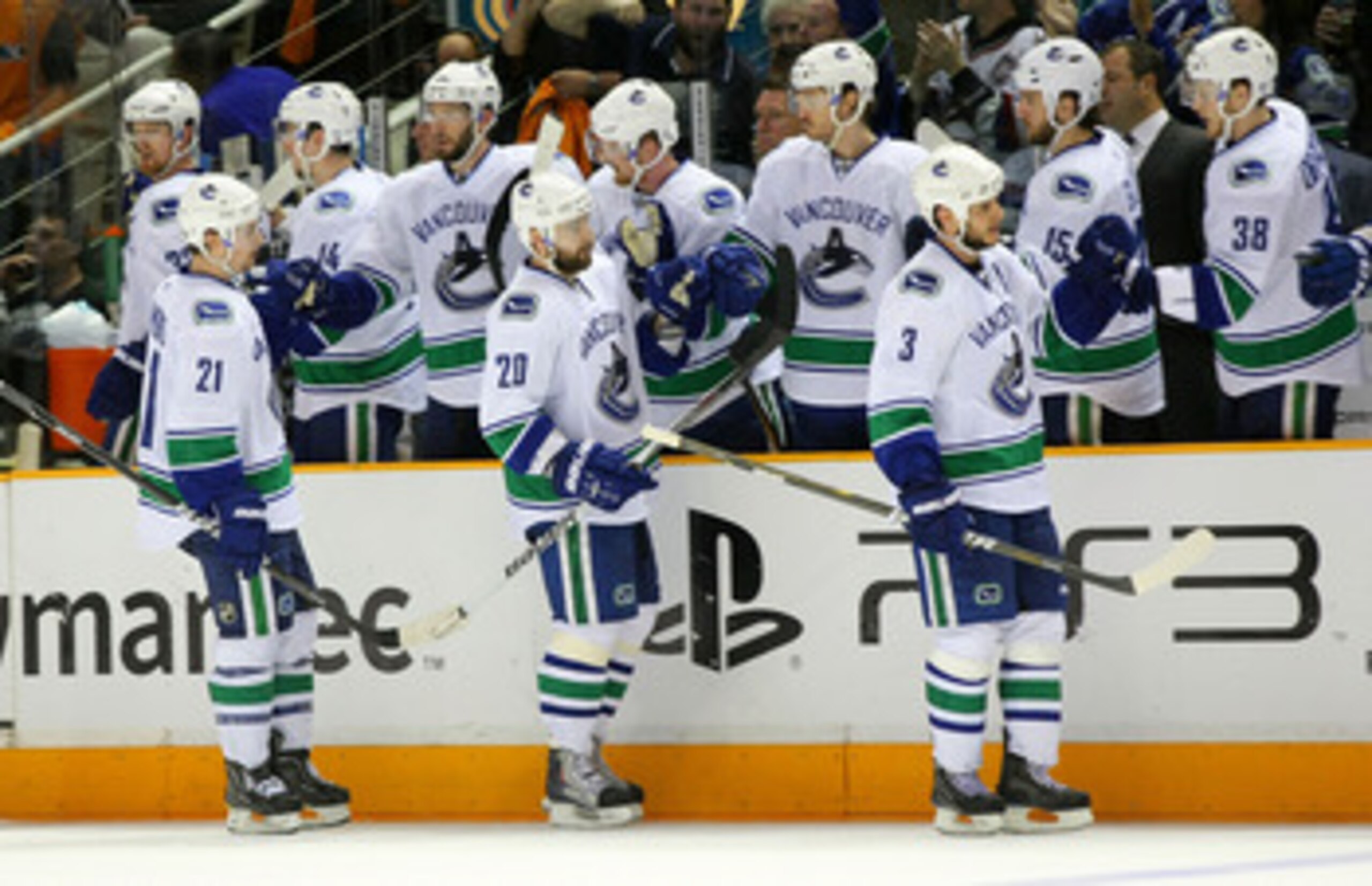 SAN JOSE, CA - MAY 20:  L(-R) Mason Raymond #21, Christopher Higgins #20 and Kevin Bieksa #3 of the Vancouver Canucks skate by the Canucks bench to celebrate Bieksa's goal in the third period in Game Three of the Western Conference Finals during the 2011