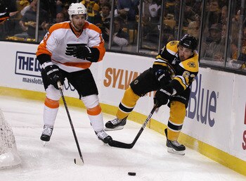 BOSTON, MA - MAY 04:  Brad Marchand #63 of the Boston Bruins passes the puck as Braydon Coburn #5 of the Philadelphia Flyers defends in Game Three of the Eastern Conference Semifinals during the 2011 NHL Stanley Cup Playoffs at TD Garden on May 4 , 2011 i