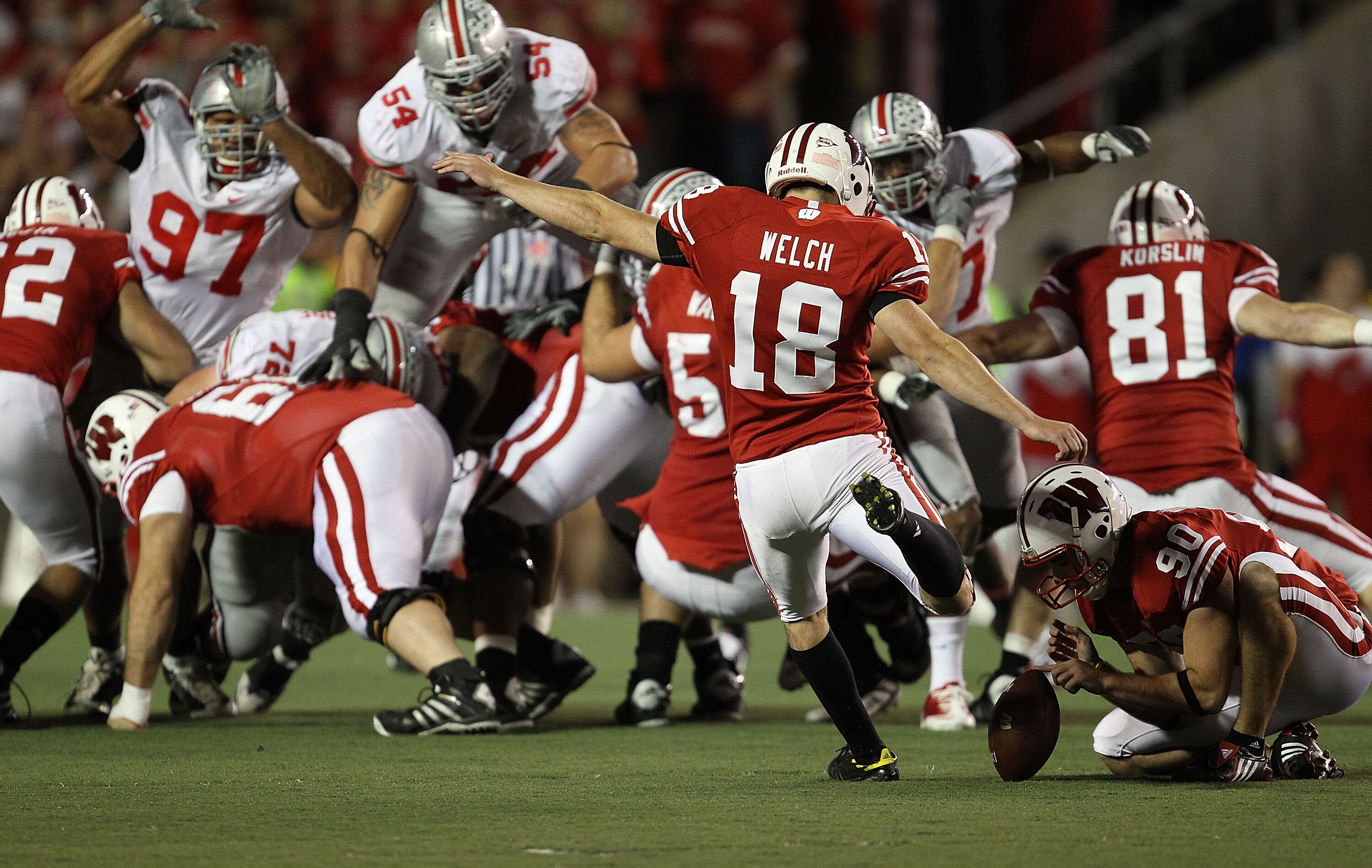 MADISON, WI - OCTOBER 16: Phillip Welch #18 of the Wisconsin Badgers kicks a field goal out of the hold of Ryan Wickesberg #90 against the Ohio State Buckeyes at Camp Randall Stadium on October 16, 2010 in Madison, Wisconsin. Wisconsin defeated Ohio State