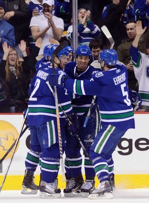 VANCOUVER, CANADA - FEBRUARY 26: Manny Malhotra #27 of the Vancouver Canucks is congratulated by Dan Hamhuis #2 and Christian Ehrhoff #5 after scoring against the Boston Bruins during the first period in NHL action on February 26, 2011 at Rogers Arena in