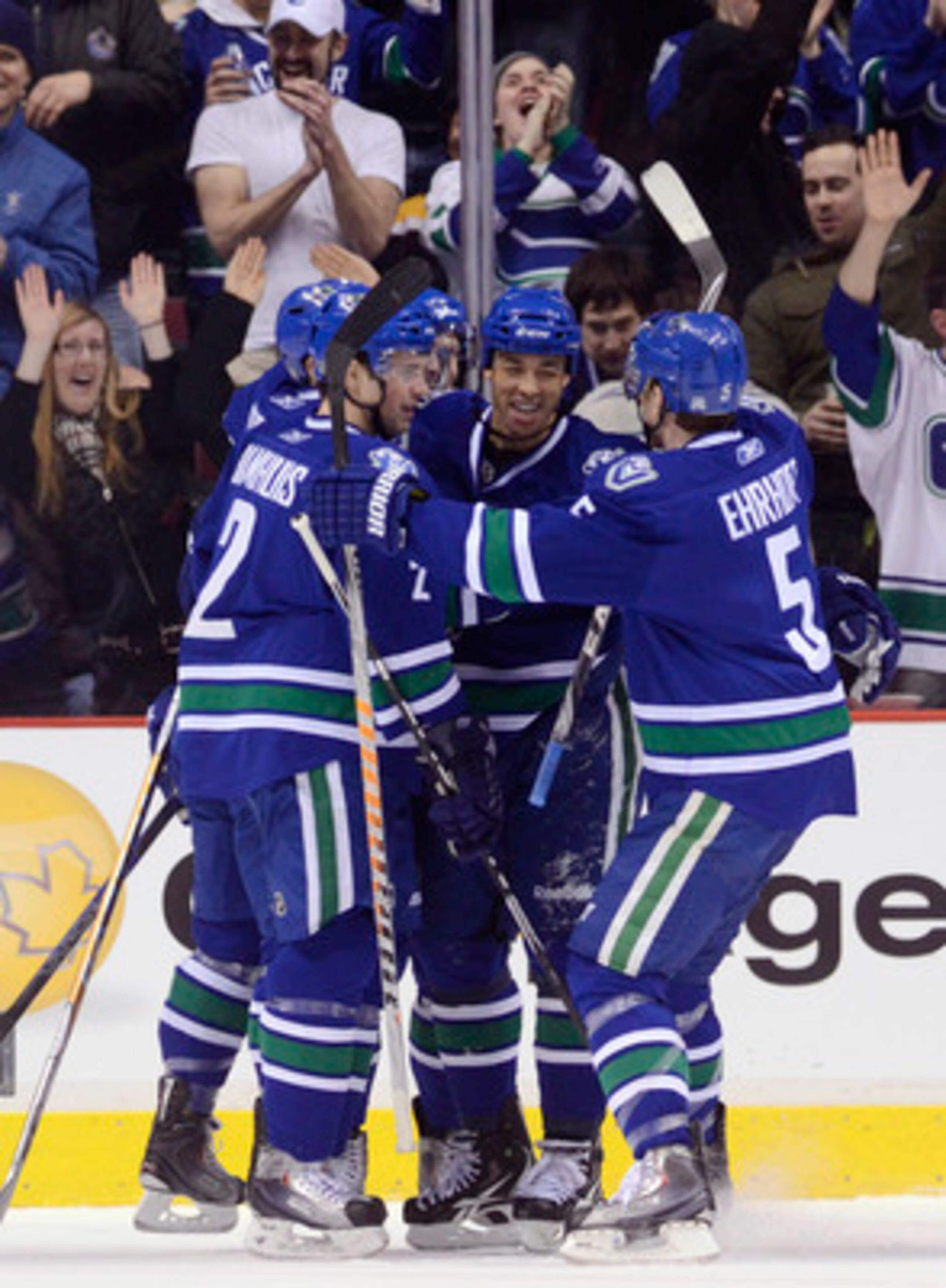 VANCOUVER, CANADA - FEBRUARY 26: Manny Malhotra #27 of the Vancouver Canucks is congratulated by Dan Hamhuis #2 and Christian Ehrhoff #5 after scoring against the Boston Bruins during the first period in NHL action on February 26, 2011 at Rogers Arena in