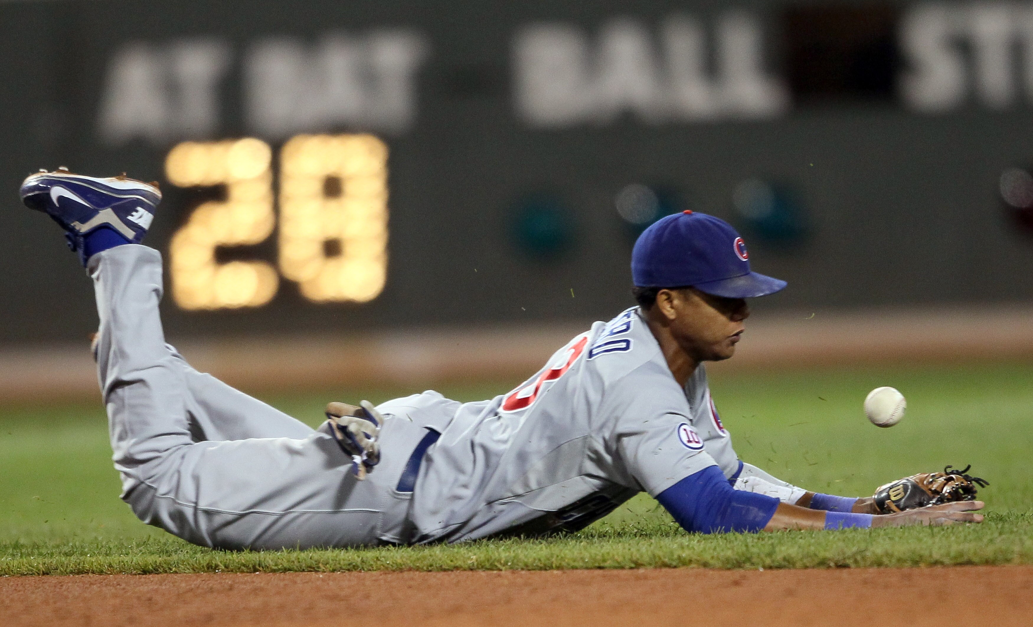 BOSTON, MA - MAY 22:  Starlin Castro #13 of the Chicago Cubs tries to stop a hits a by Adrian Gonzalez of the Boston Red Sox on May 22, 2011 at Fenway Park in Boston, Massachusetts.  Before this series, the two teams haven't played at Fenway Park since th