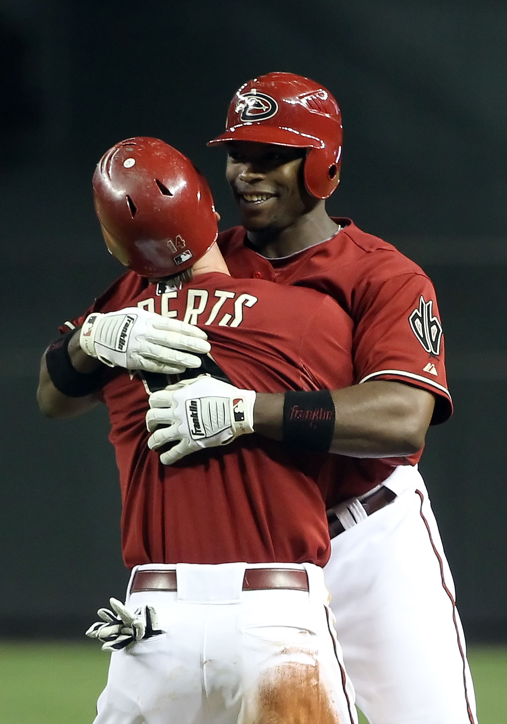 PHOENIX, AZ - MAY 18:  Justin Upton #10 and Ryan Roberts #14 of the Arizona Diamondbacks celebrate after Upton had the game winning RBI single against the Atlanta Braves in the eleventh inning of the Major League Baseball game at Chase Field on May 18, 20