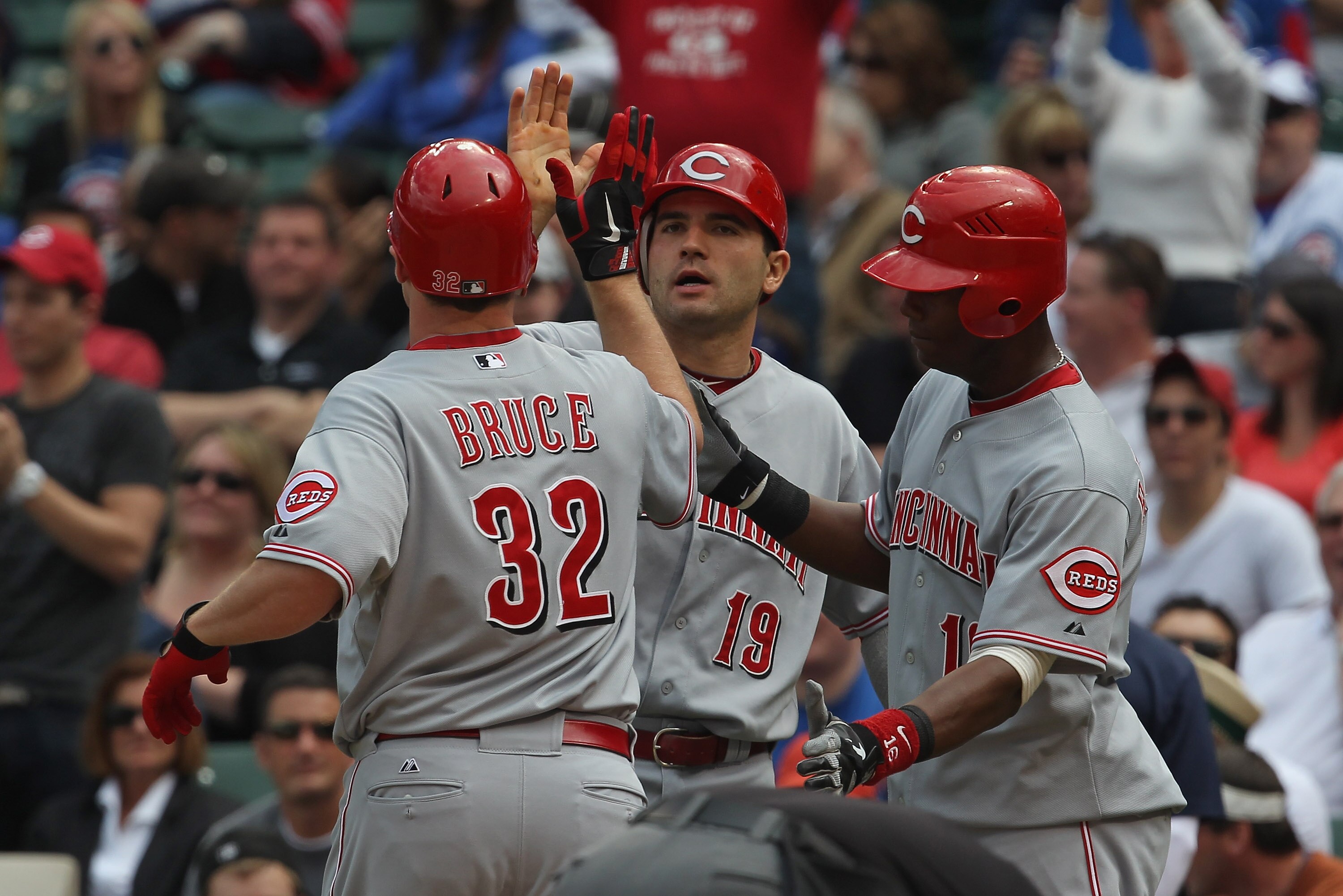 CHICAGO, IL - MAY 06: Jay Bruce #32 of the Cincinnati Reds is greeted by teammates Joey Votto #19 and Edgar Renteria #16 after hitting a three-run home run in the 4th inning against the Chicago Cubs at Wrigley Field on May 6, 2011 in Chicago, Illinois. (P