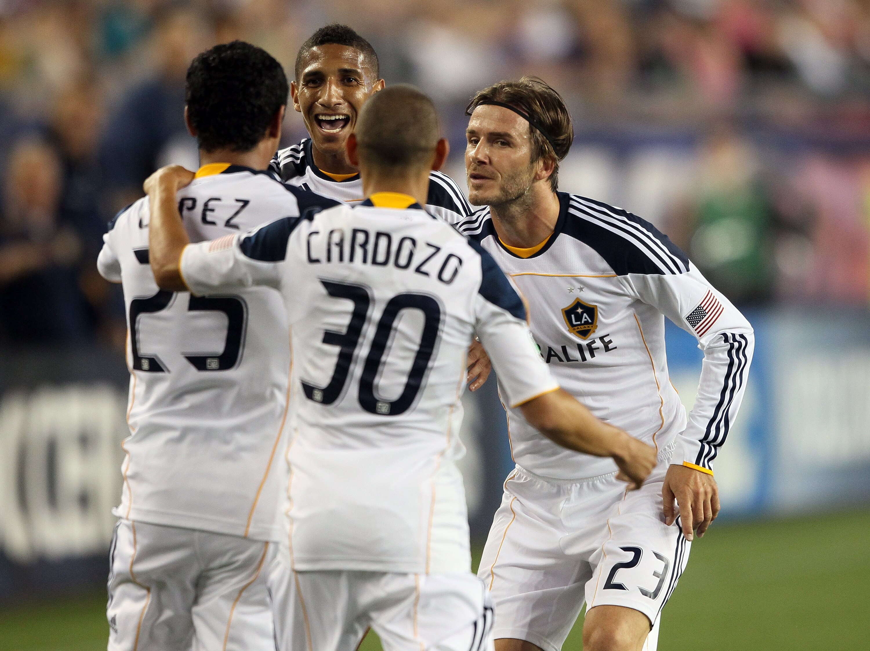 FOXBORO, MA - MAY 28:  Miguel Lopez #25 of the Los Angeles Galaxy is congratulated by teammates David Beckham #23, Sean Franklin #5 and Paolo Cardozo #30 after Lopez scored the game winning goal in the second half against the New England Revolution on May