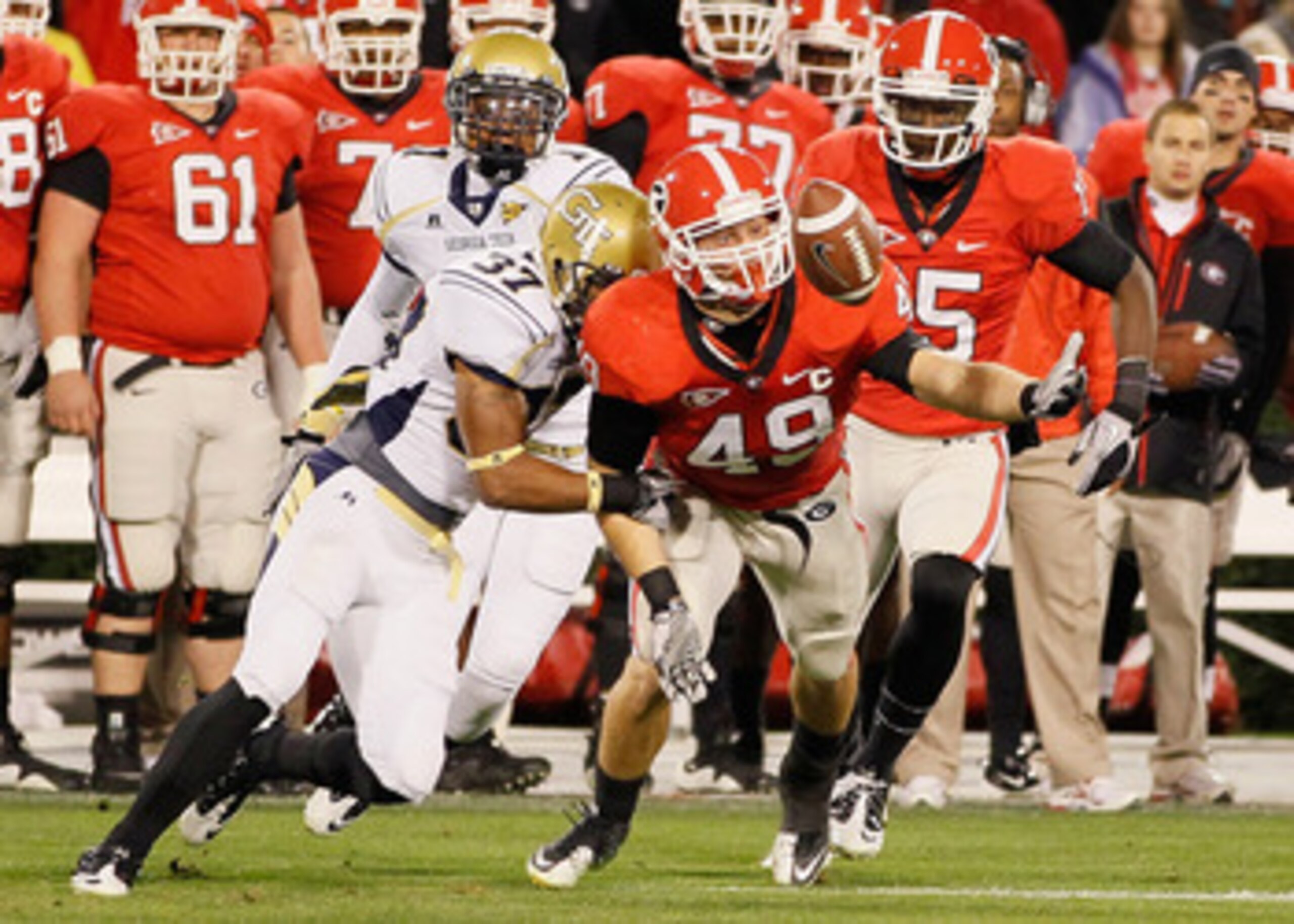 ATHENS, GA - NOVEMBER 27:  Jerrard Tarrant #37 of the Georgia Tech Yellow Jackets forces a fumble by Shaun Chapas #49 of the Georgia Bulldogs on the opening kickoff at Sanford Stadium on November 27, 2010 in Athens, Georgia.  (Photo by Kevin C. Cox/Getty 