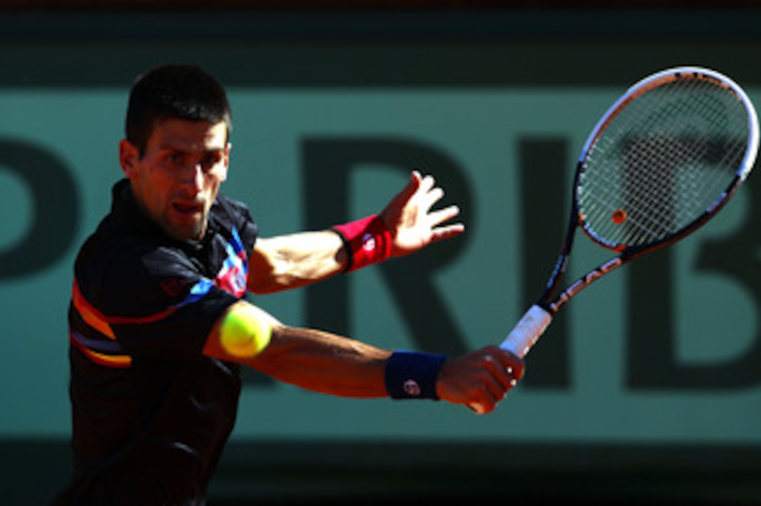 PARIS, FRANCE - MAY 25:  Novak Djokovic of Serbia hits a backhand during the men's singles round two match between Victor Hanescu of Romania and Novak Djokovic of Serbia on day four of the French Open at Roland Garros on May 25, 2011 in Paris, France.  (P