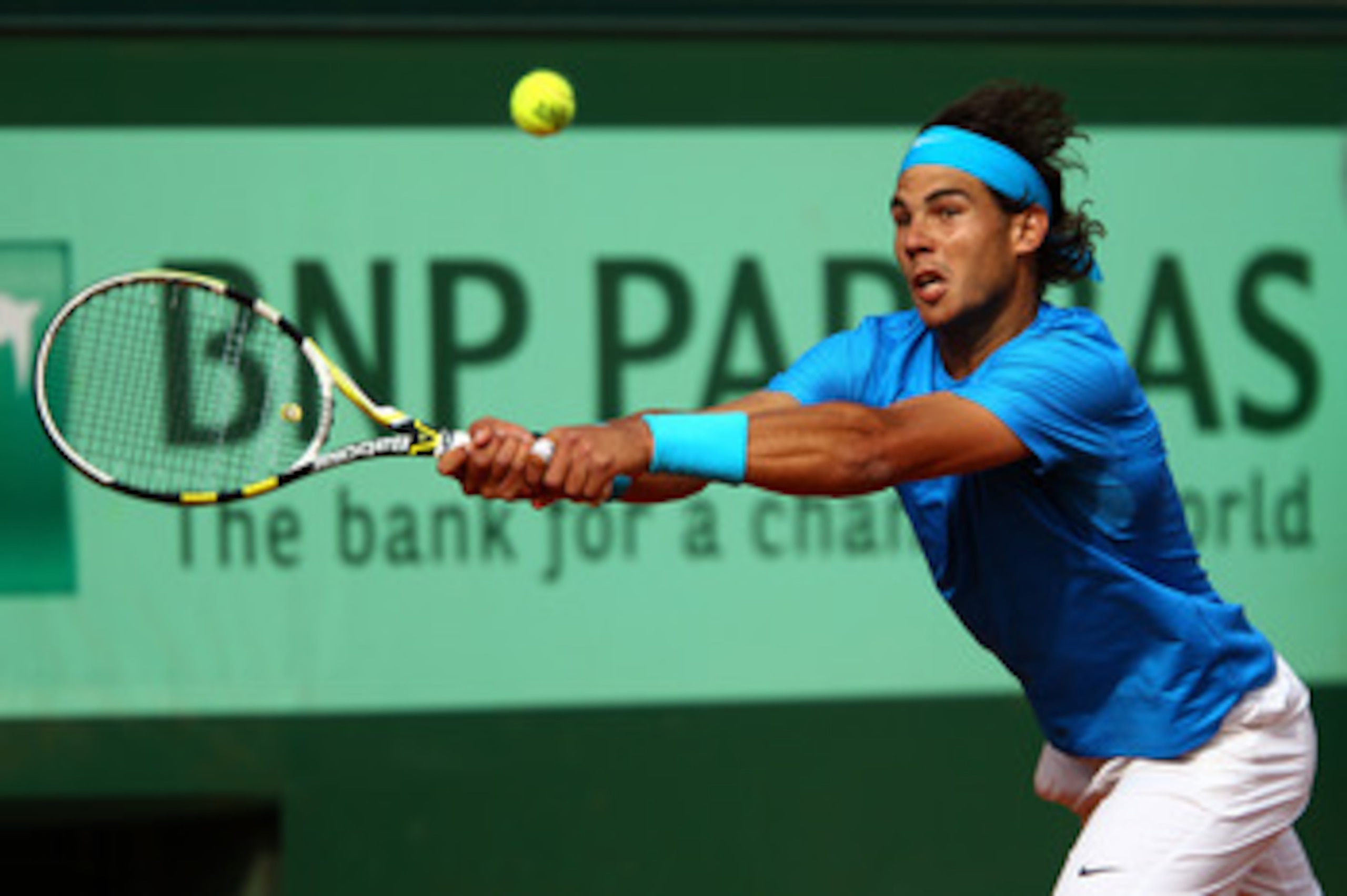 PARIS, FRANCE - MAY 24:  Rafael Nadal of Spain stretches to hit a backhand during the men's singles round one match between Rafael Nadal of Spain and John Isner of USA on day three of the French Open at Roland Garros on May 24, 2011 in Paris, France.  (Ph