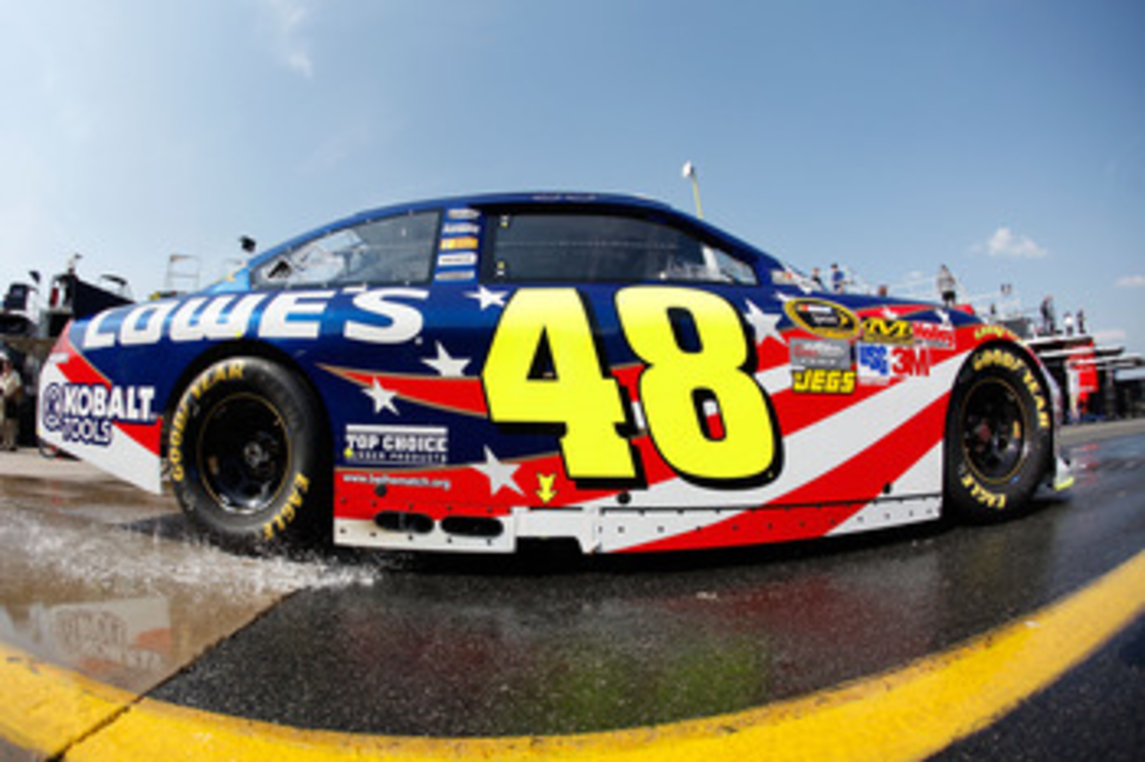 CHARLOTTE, NC - MAY 26:  Jimmie Johnson drives the #48 Lowe's Summer Salute Chevrolet through the garage area during practice for the NASCAR Sprint Cup Series Coca-Cola 600 at Charlotte Motor Speedway on May 26, 2011 in Charlotte, North Carolina.  (Photo 