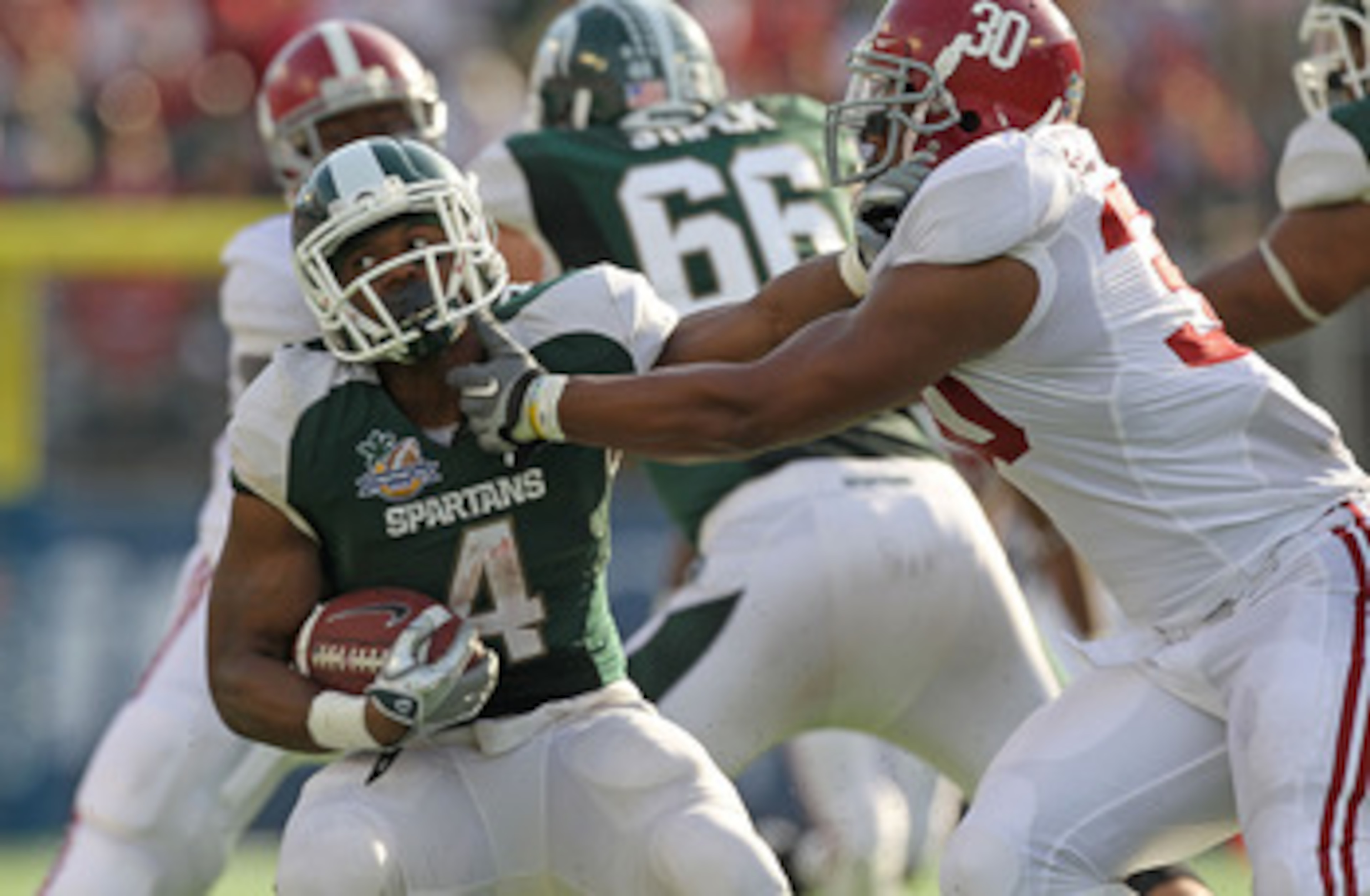ORLANDO, FL - JANUARY 01: Edwin Baker #4 of the Michigan State Spartans stiff arms Dont'a Hightower #30 of the Alabama Crimson Tide during the Capitol One Bowl at the Florida Citrus Bowl on January 1, 2011 in Orlando, Florida. (Photo by Mike Ehrmann/Get ORLANDO, FL - JANUARY 01: Edwin Baker #4 of the Michigan State Spartans stiff arms Dont'a Hightower #30 of the Alabama Crimson Tide during the Capitol One Bowl at the Florida Citrus Bowl on January 1, 2011 in Orlando, Florida. (Photo by Mike Ehrmann/Get