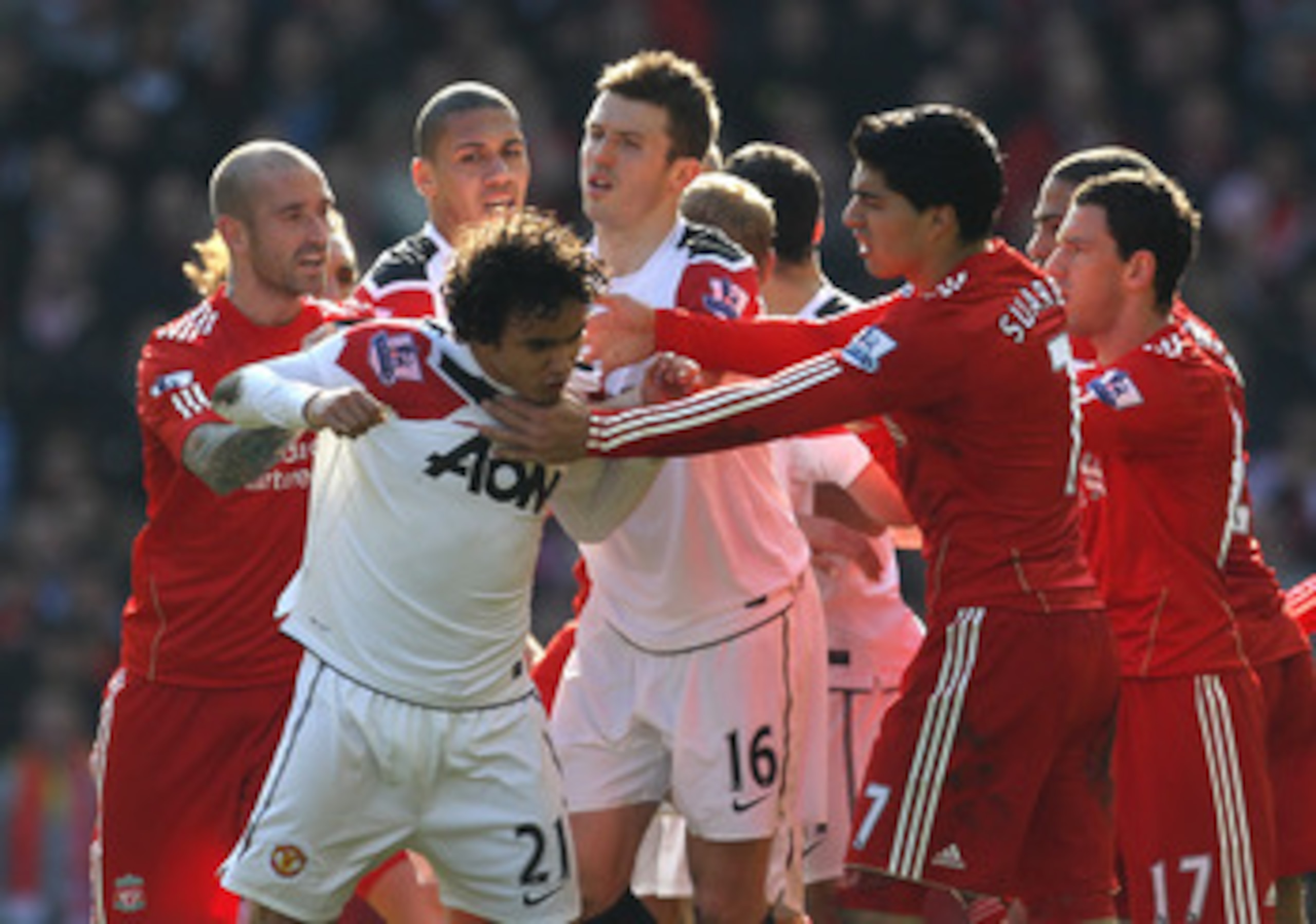LIVERPOOL, ENGLAND - MARCH 06:  Rafael of Manchester United is restrained following his challenge on Lucas of Liverpool during the Barclays Premier League match between Liverpool and Manchester United at Anfield on March 6, 2011 in Liverpool, England.  (P